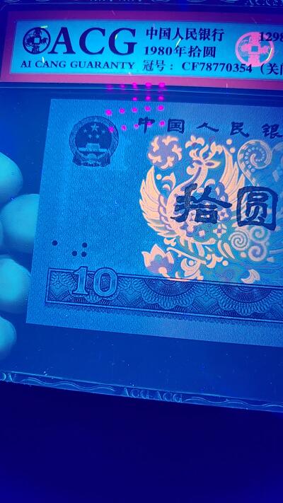 周六拍场，纸币、古币、邮票 爱藏评级8010—浴火凤凰，关门冠CF78770354。灯下金凤凰荧光，由于送评较早，当时金凤凰还没有开标，可见灯下荧光
