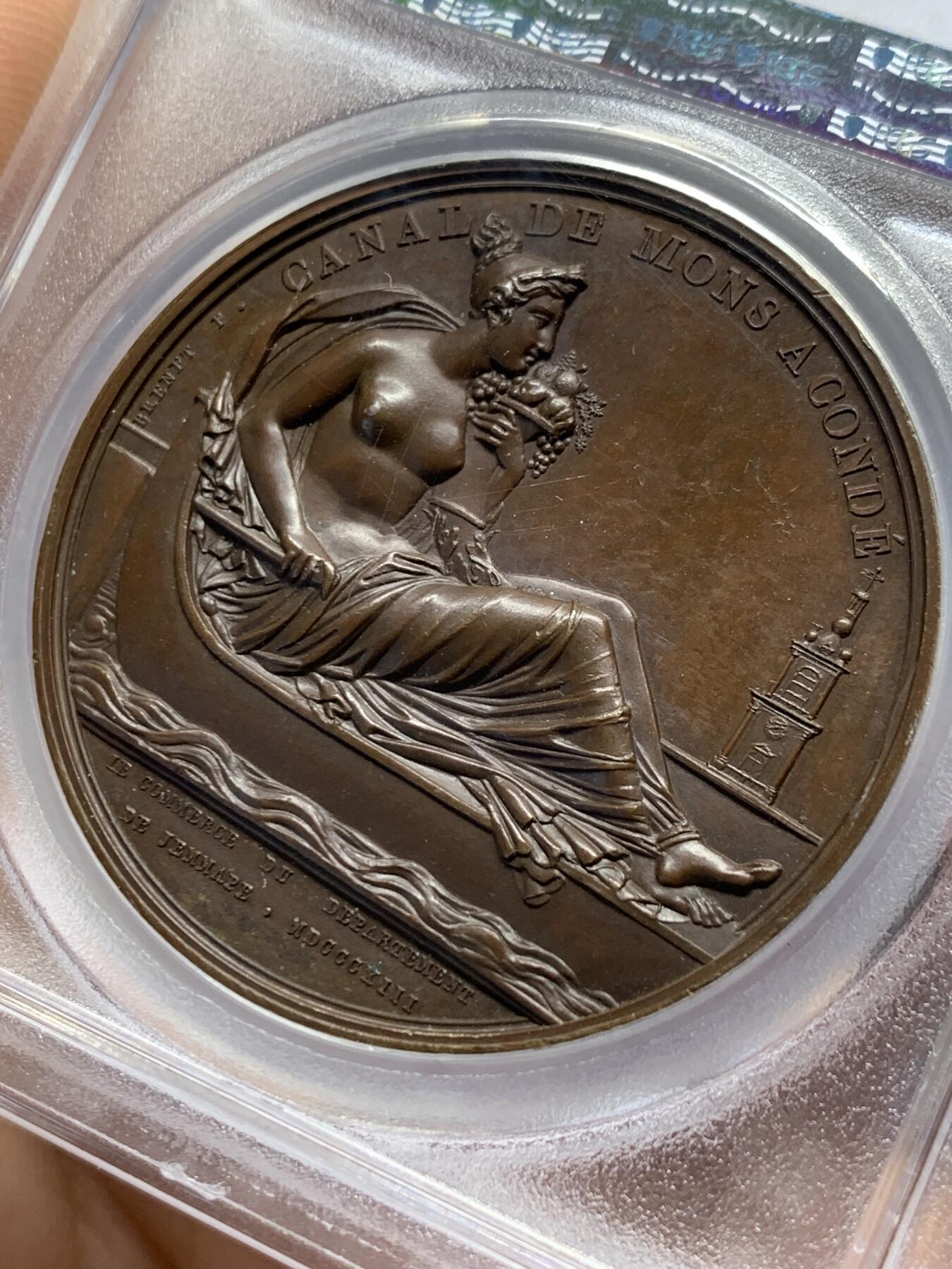 《竞宝斋》第377场 周日，周一 2场连拍 （全场包邮） PCGS SP63 亚军分 法国1813年拿破仑幸运女神原铸铜章  巴黎造币厂巧克力包浆 幸运女神费利西塔坐于船上 身姿优雅 裙摆飘逸 左手持丰饶角右手掌舵 徐徐而行 远处蒙斯的钟楼在水一方 纪念蒙斯到孔戴的运河修建竣工 一展法兰西帝国国力昌盛 加厚盒