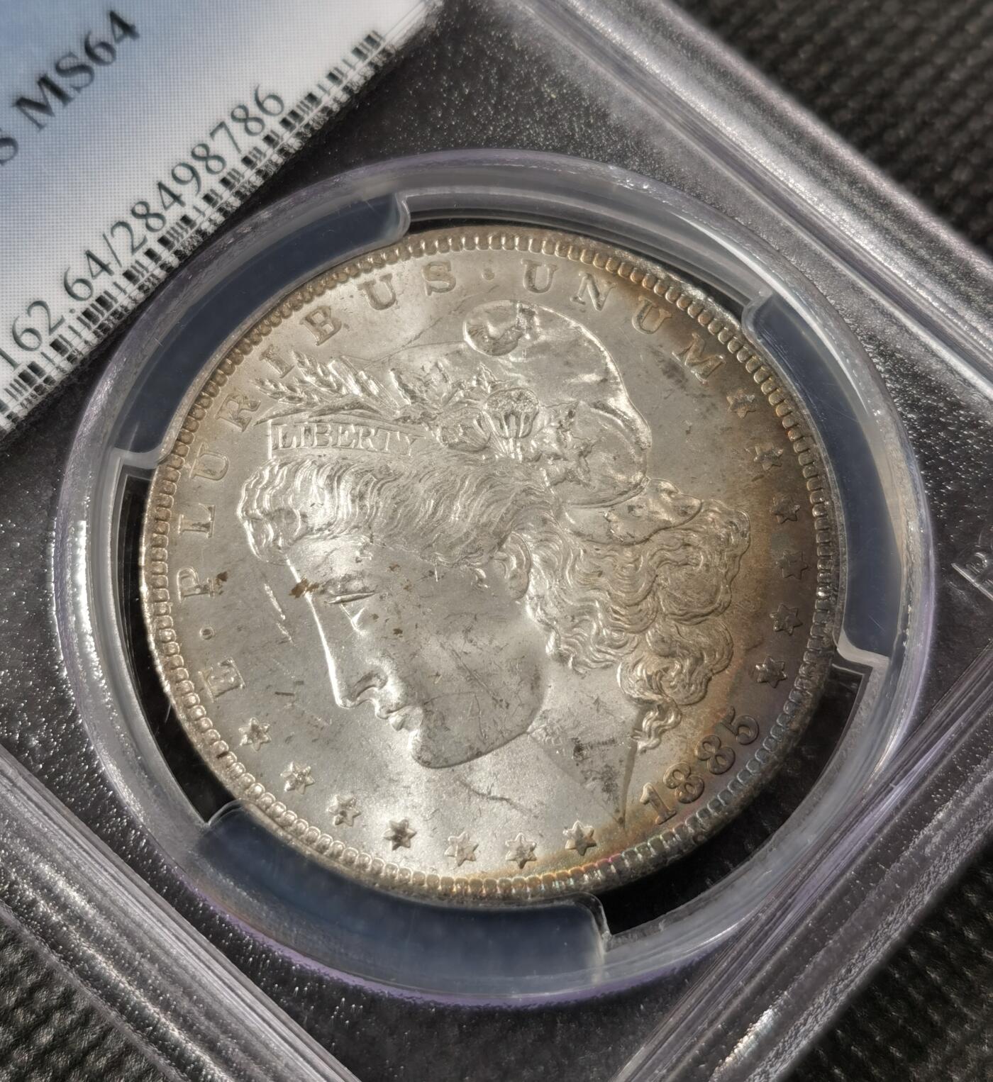  甄臻铺-美国银币专场-世界币章拍卖（第17期），送拍享返佣金等优惠多多 PCGS-MS64 美国1885年O版摩根银币一元，正面月牙五彩，背部酱彩色包浆，盒子有小磕