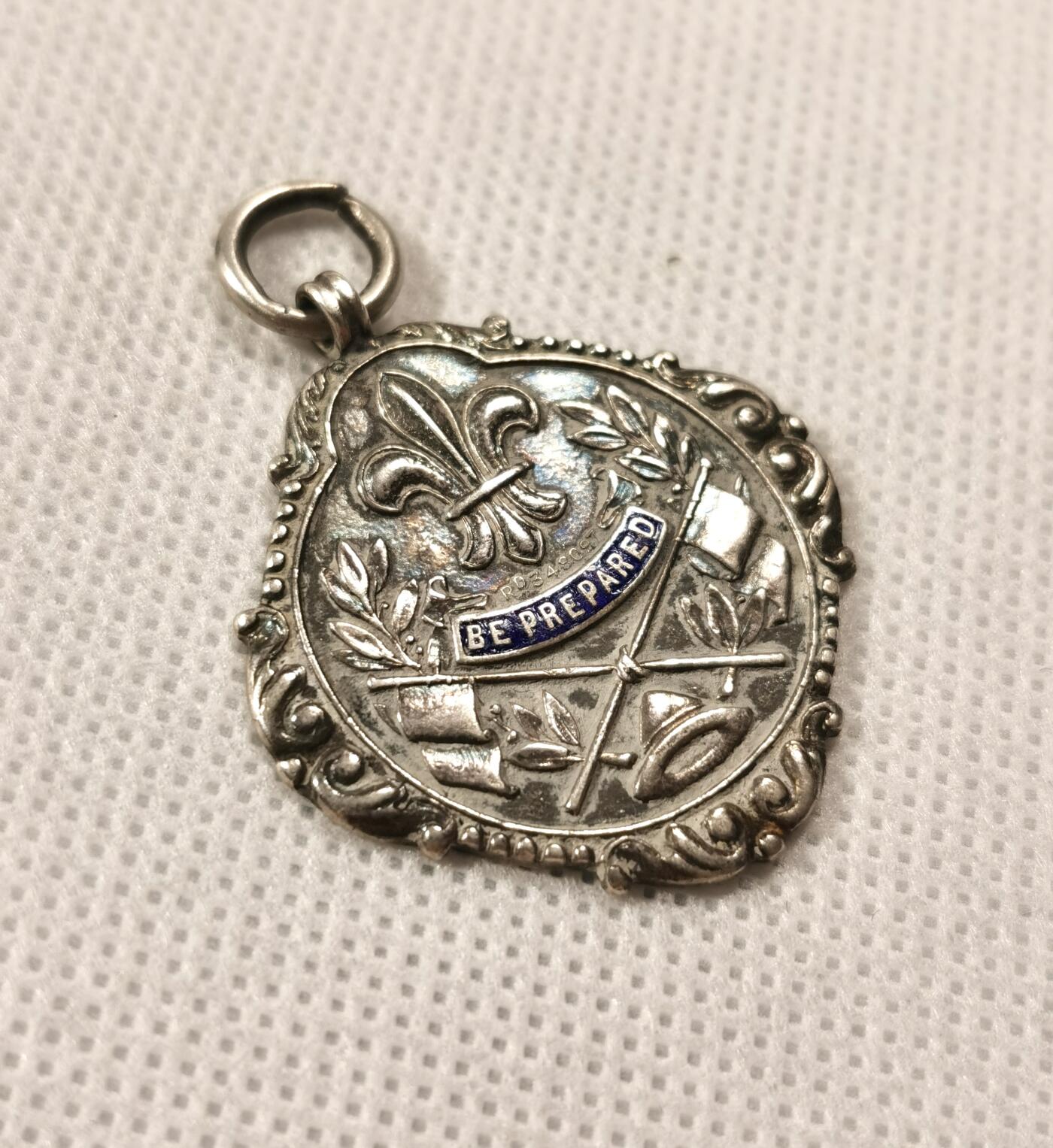  甄臻铺-世界币章拍卖（第19期），送拍享返佣金等优惠多多 1905年童子军奖章，属早期版本，左右尺寸31.3毫米，重9.8克，银质带珐琅，保存完好，带英国官方贵金属设计注册号Rd348097。奖章正面刻有“BE PREPARED”及徽章图案，背面光滑，有磨损痕迹，由银器大师A•F制作。适合收藏或展示，具有历史稀缺性。