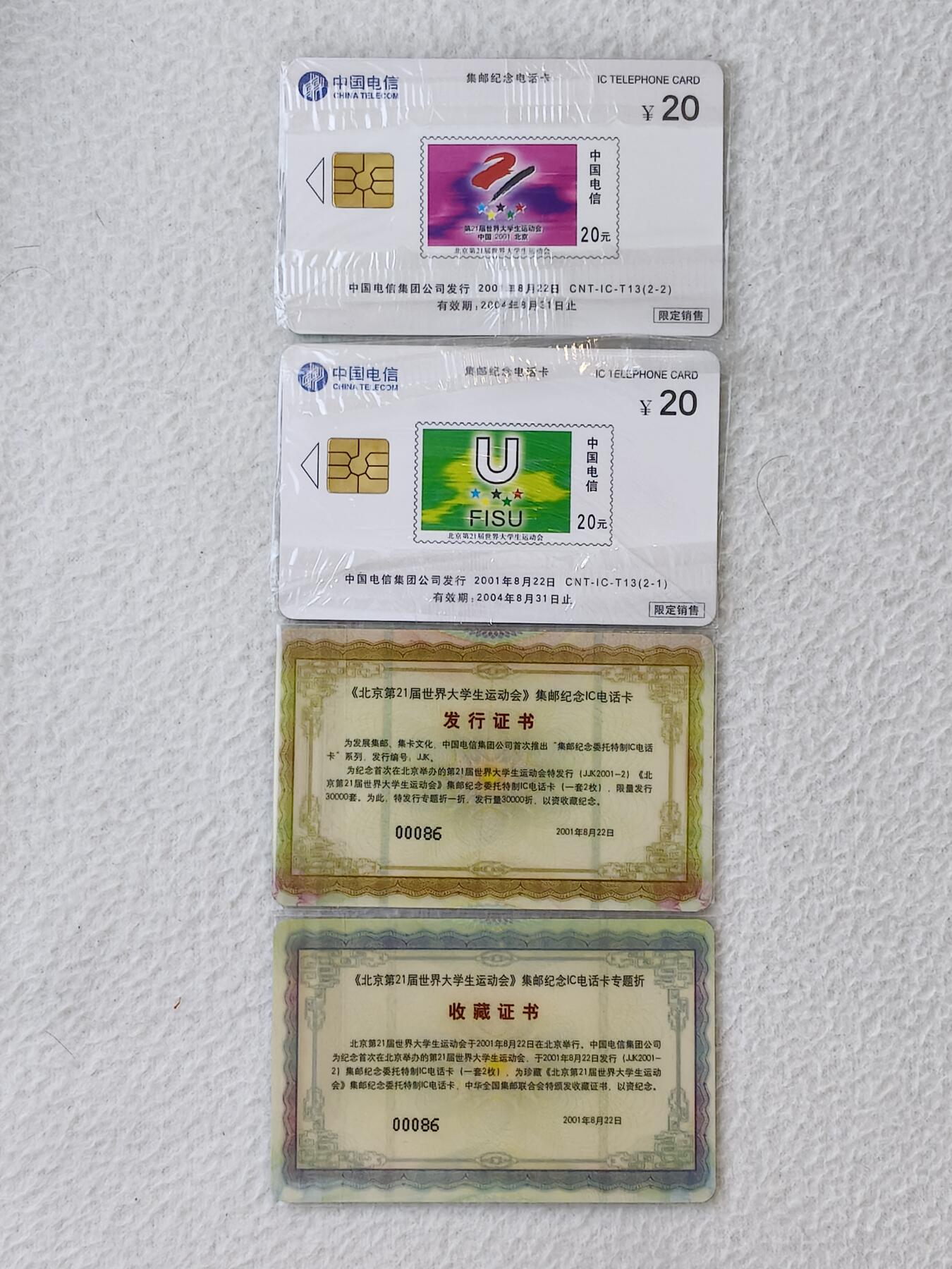 易卡拍卖第21期 IC—T13北京第二十一届世界大学生运动会（集邮纪念电话卡）DZ电总版（带两枚收藏证书，编号为00086。比较希少）。全新卡，带原封套。品相如图所示。