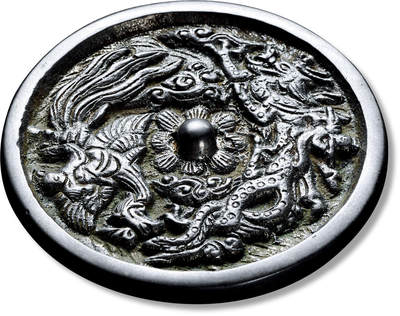 上海匡时2025年春季拍卖会 龙凤镜，直径：7.1cm，厚：0.48cm，重：116.6g，圆形，花瓣纹钮座，主纹饰为高浮雕龙凤，线条流畅，刻画生动，栩栩如生。