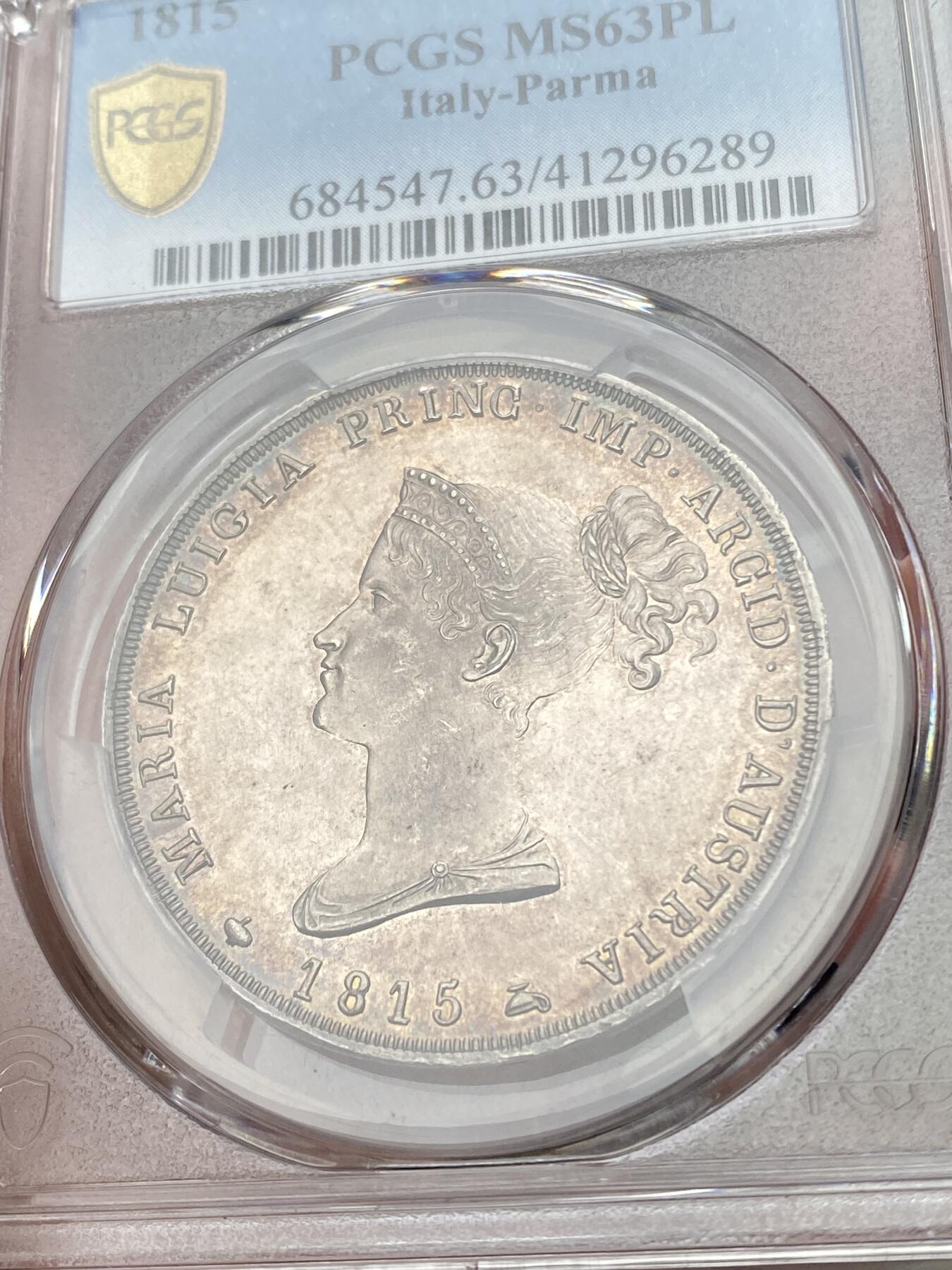 万国钱币拍卖第049期（万国夏季大拍） PCGS MS63PL 1815意大利帕尔马5里拉银币 正面帕尔马女大公是拿皇的妻子玛丽亚·路易斯，背面帕尔马纹章繁复华丽，好品极其难得的意系大银，国际市场广受欢迎品种，获得PL评分的更是凤毛麟角，均匀一色的玫瑰彩包浆搭配类镜面质感的底板，典藏级品质。