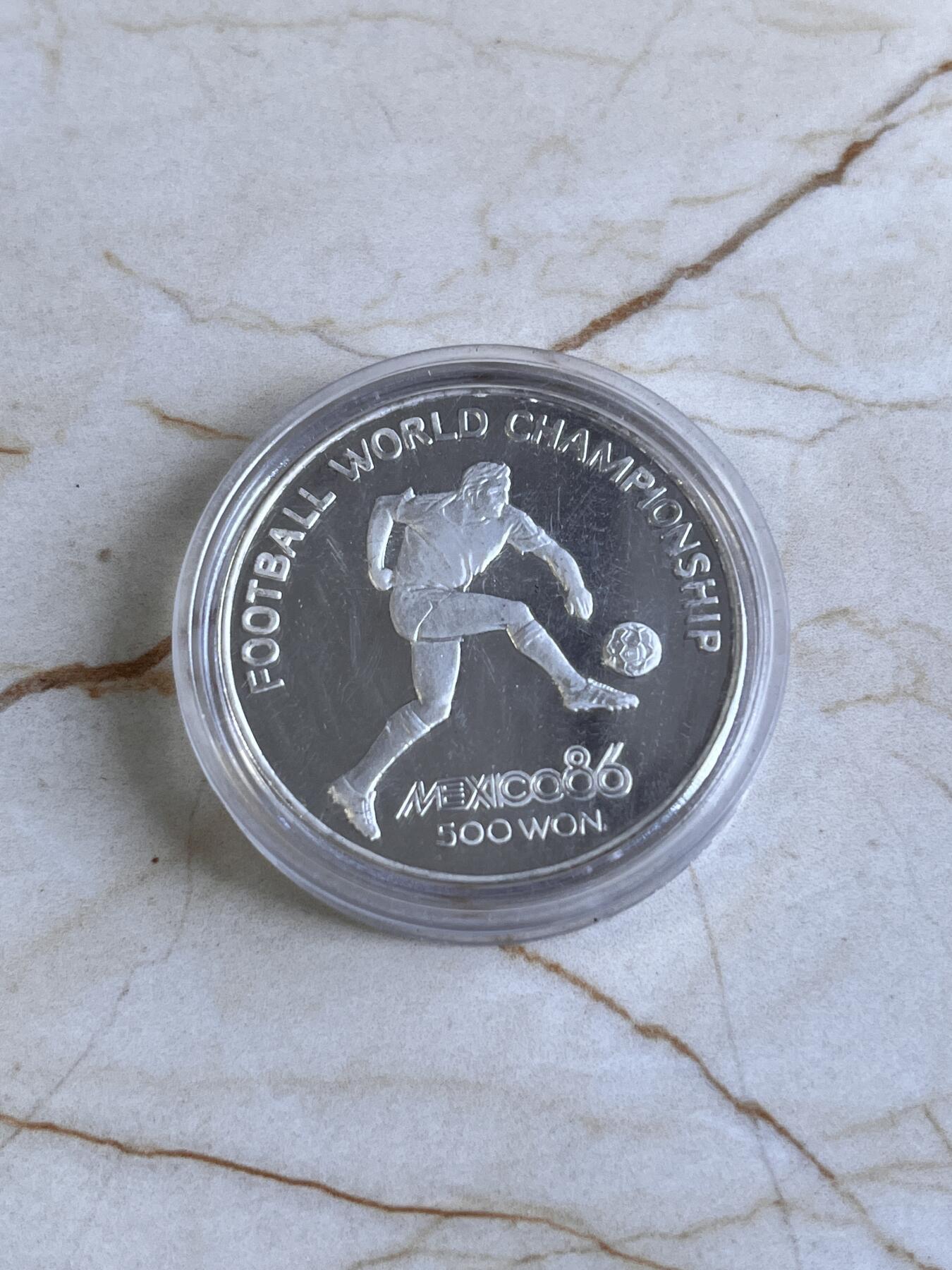 第166期拍卖【长期征集拍品】 朝鲜首枚纪念银币—朝鲜1987年世界杯足球27克纪念银币，999银，直径35毫米