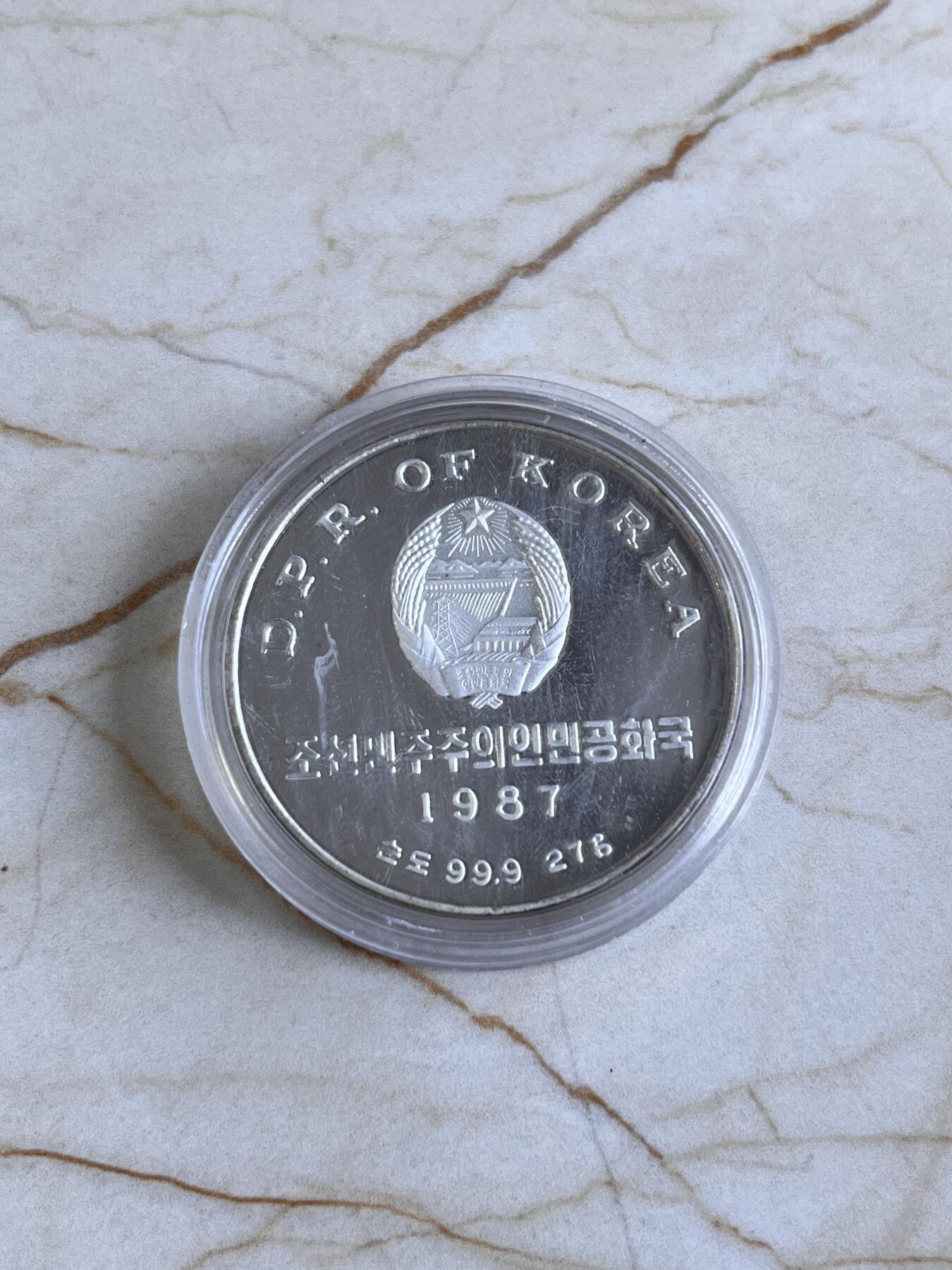 第166期拍卖【长期征集拍品】 朝鲜首枚纪念银币—朝鲜1987年世界杯足球27克纪念银币，999银，直径35毫米