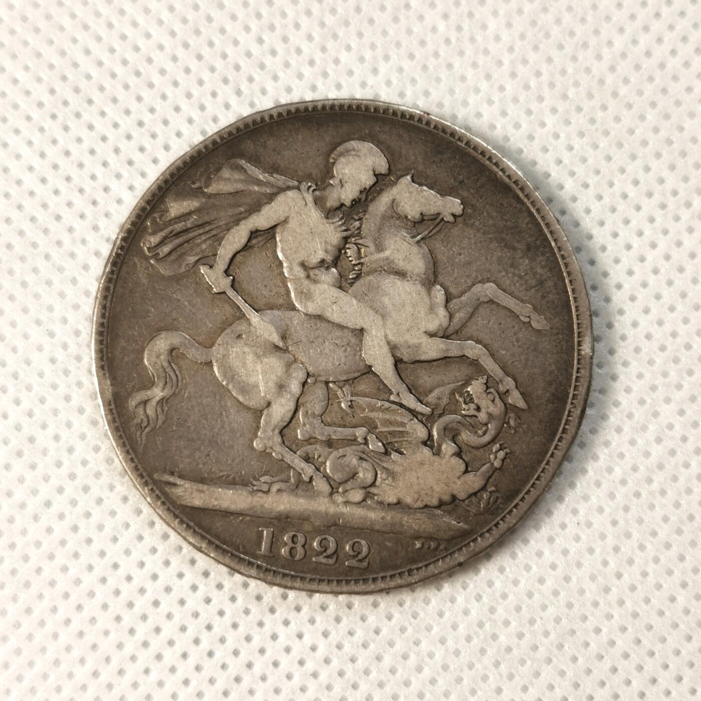  甄臻铺-世界币章拍卖（第25期），送拍享返佣金等优惠多多 1822年英国乔治四世马剑银币，正面刻有国王头像和橄榄枝装饰，背面是骑士屠龙图案，年份清晰可见。银币直径约38毫米，重27.5克，边铭可见。自然流通老包浆，正面加盖MB戳