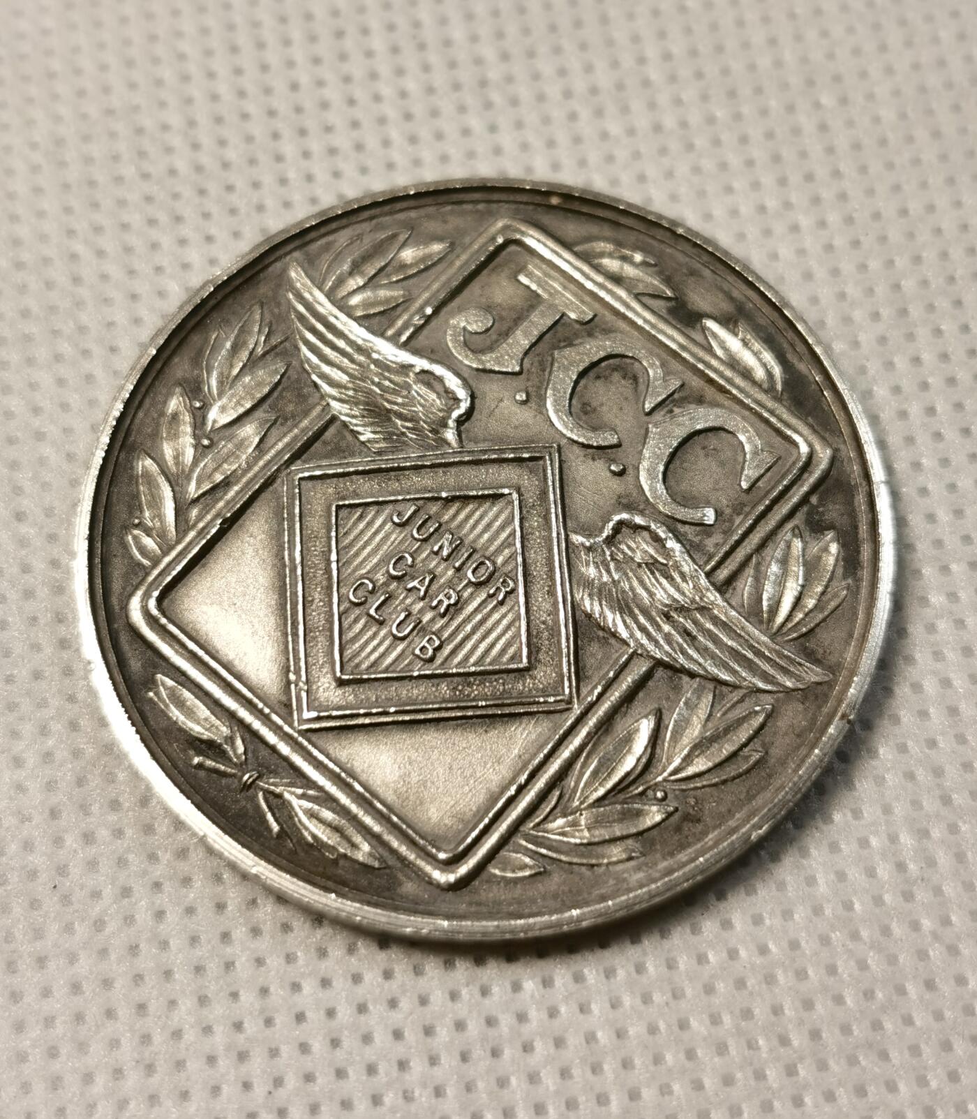  甄臻铺-世界币章拍卖（第25期），送拍享返佣金等优惠多多 1933年英国JCC Junior Car Club赛车俱乐部获奖银章，正面刻有JCC标志和翅膀图案，环绕橄榄枝装饰，背面刻有