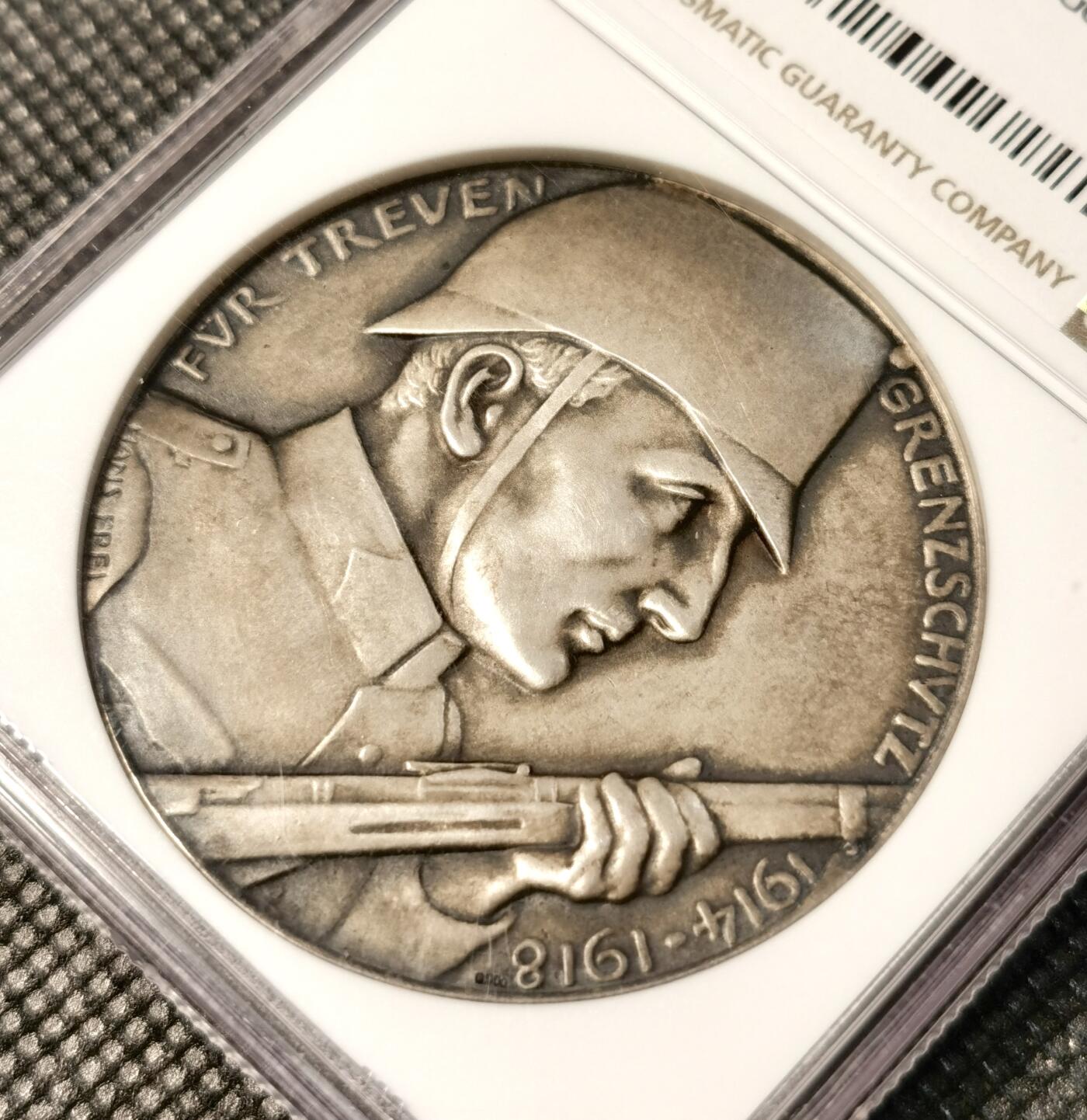  甄臻铺-世界币章拍卖（第25期），送拍享返佣金等优惠多多 NGC-MS64 瑞士1918年忠诚边防军颁发的纪念银章，直径45毫米，参考手册编号AEPPLI-279。正面是士兵持枪侧脸像，背面是盾牌和火焰纹章图案，由当地市政厅授权发行，工艺精湛。