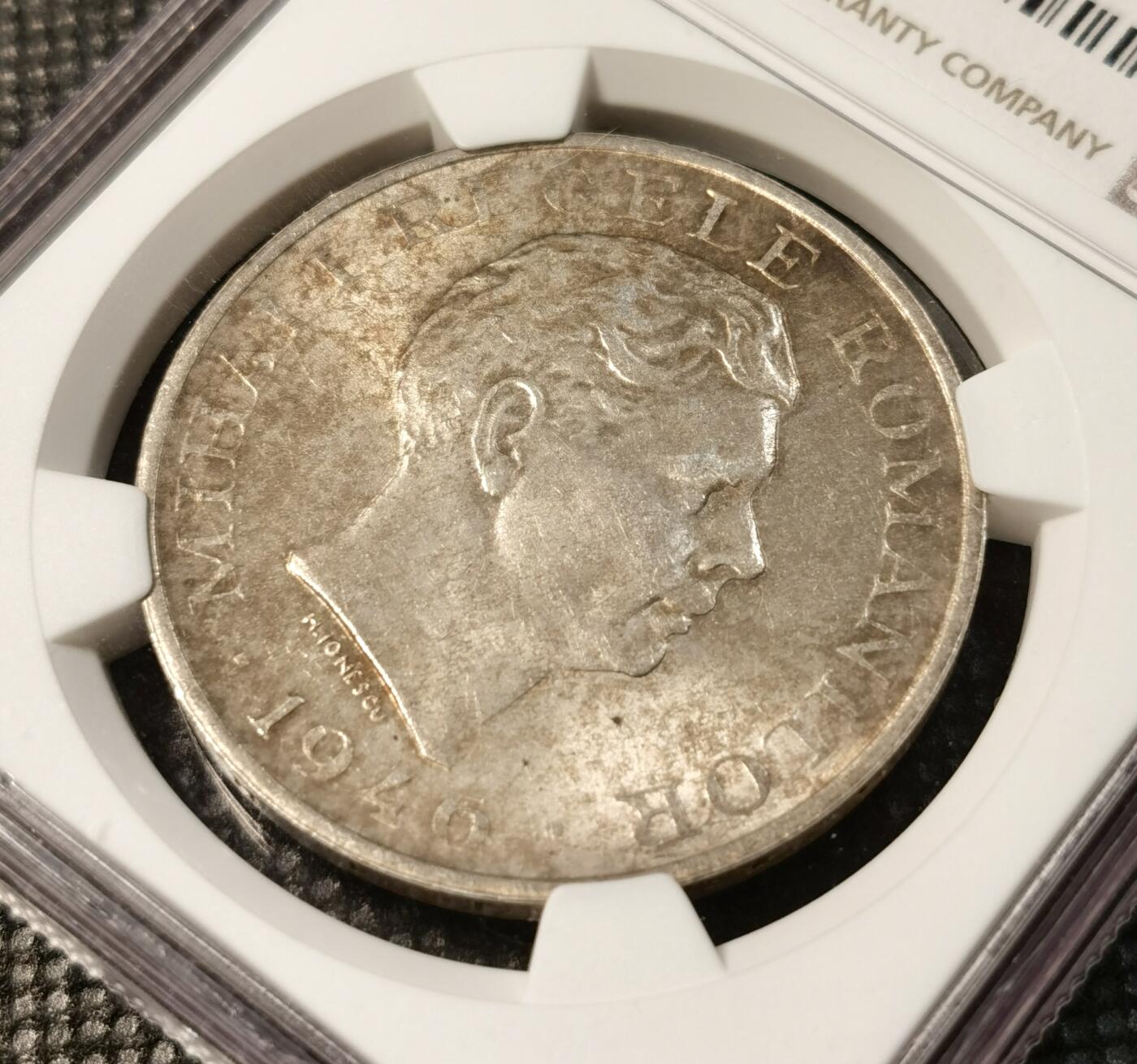  甄臻铺-世界币章拍卖（第25期），送拍享返佣金等优惠多多 NGC-MS63 罗马尼亚王国1946年米哈伊一世100000列伊银币。罗马尼亚王国银币最大面额，关门币。正面是末代国王米哈伊一世，背面是国徽及裹头巾罗马尼亚妇女双手祈祷，祈望和平鸽降临。灰常富有象征意义和时代特色。