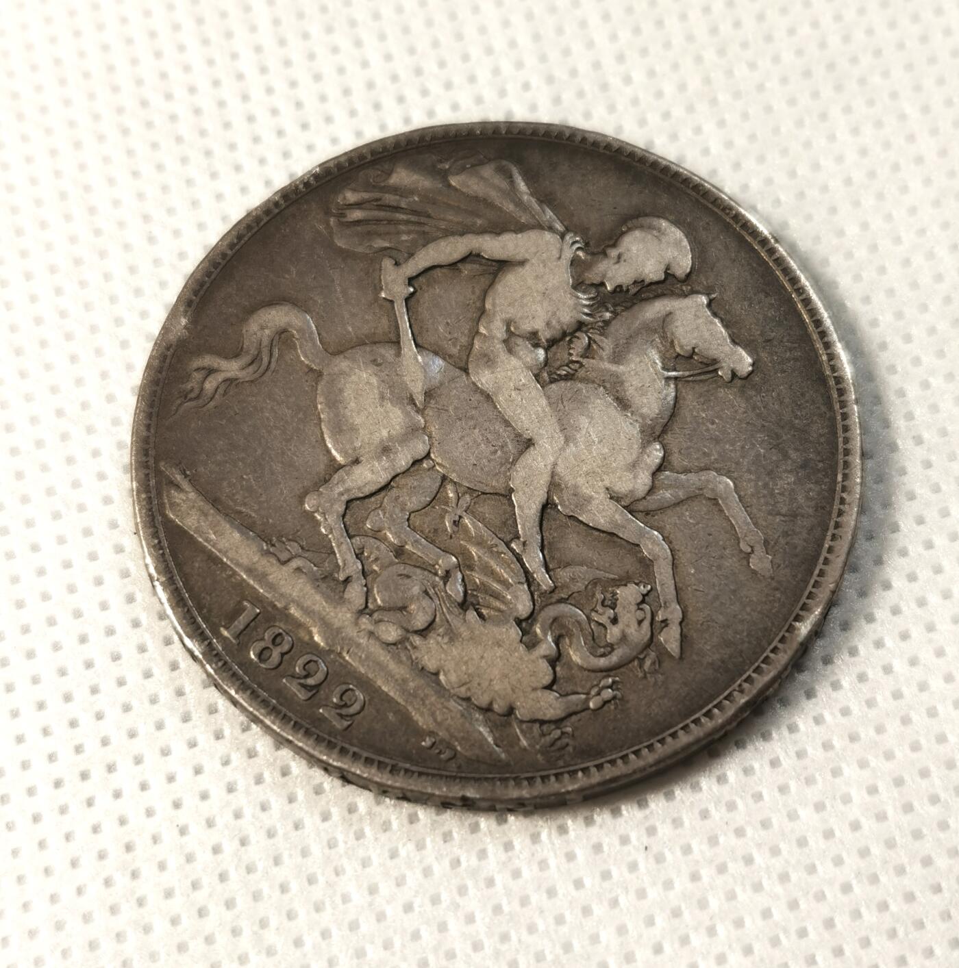  甄臻铺-世界币章拍卖（第25期），送拍享返佣金等优惠多多 1822年英国乔治四世马剑银币，正面刻有国王头像和橄榄枝装饰，背面是骑士屠龙图案，年份清晰可见。银币直径约38毫米，重27.5克，边铭可见。自然流通老包浆，正面加盖MB戳