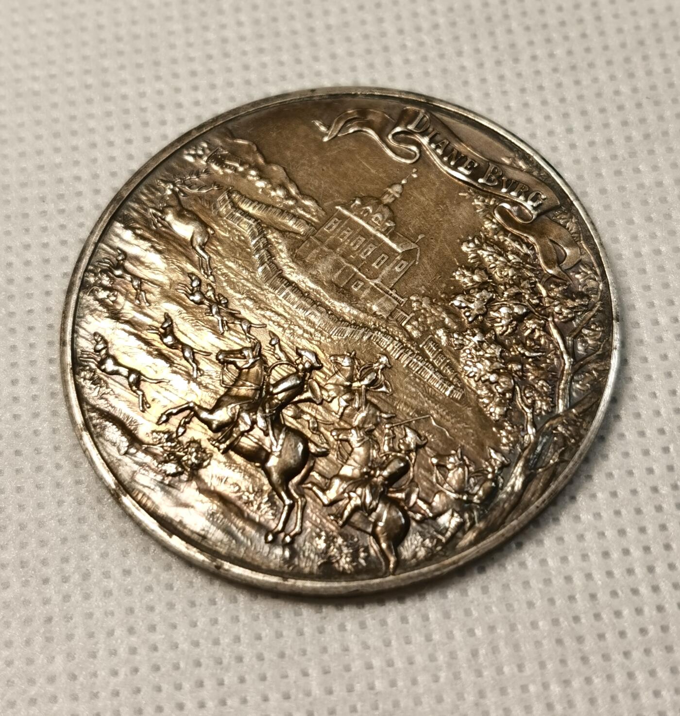  甄臻铺-世界币章拍卖（第25期），送拍享返佣金等优惠多多 德国黑森狩猎俱乐部Darmstadt颁发的银质奖章，正面刻有狩猎场景和Diane Burg字样，背景是城堡和树木，雕工精美。背面刻有