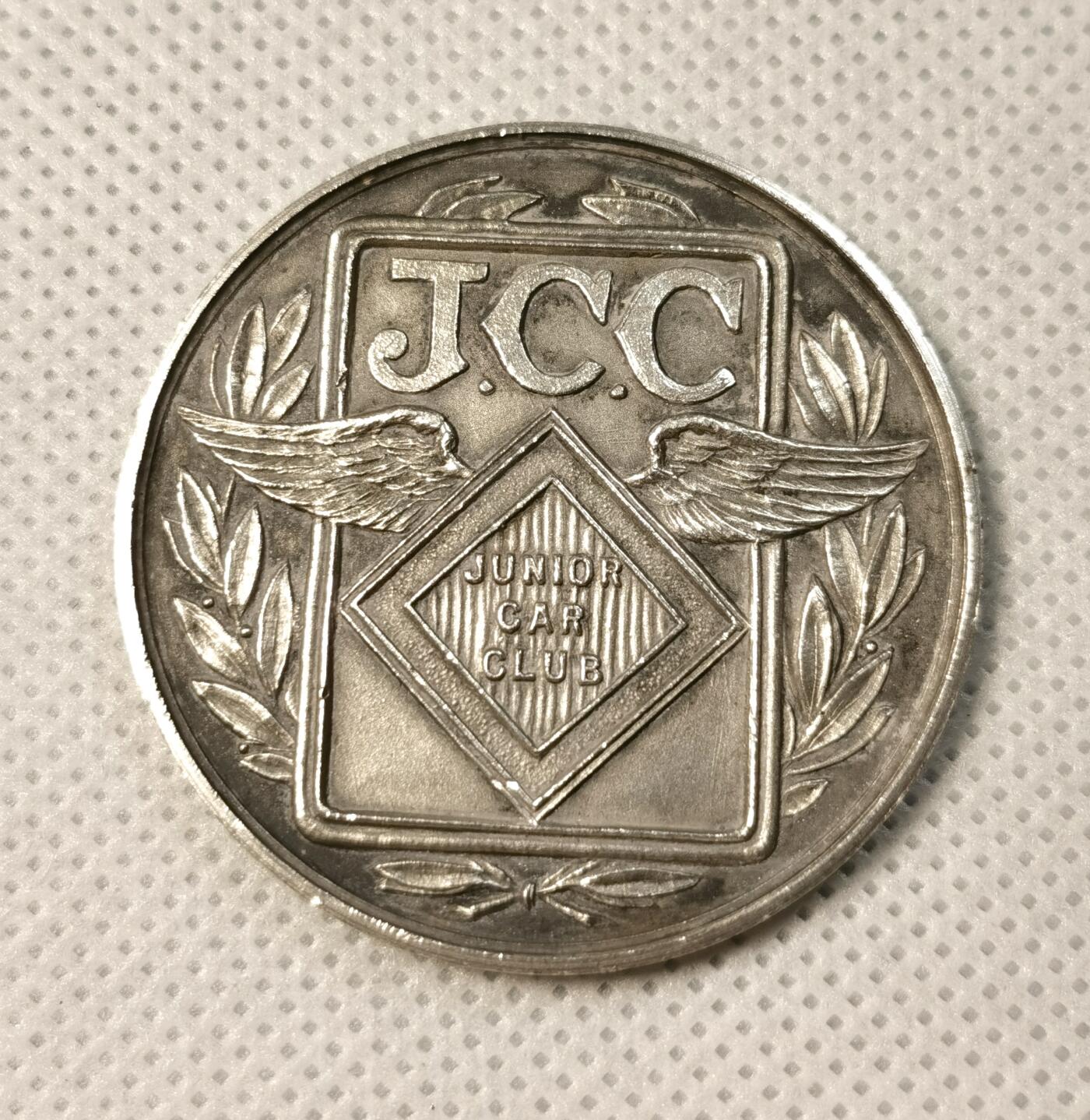  甄臻铺-世界币章拍卖（第25期），送拍享返佣金等优惠多多 1933年英国JCC Junior Car Club赛车俱乐部获奖银章，正面刻有JCC标志和翅膀图案，环绕橄榄枝装饰，背面刻有