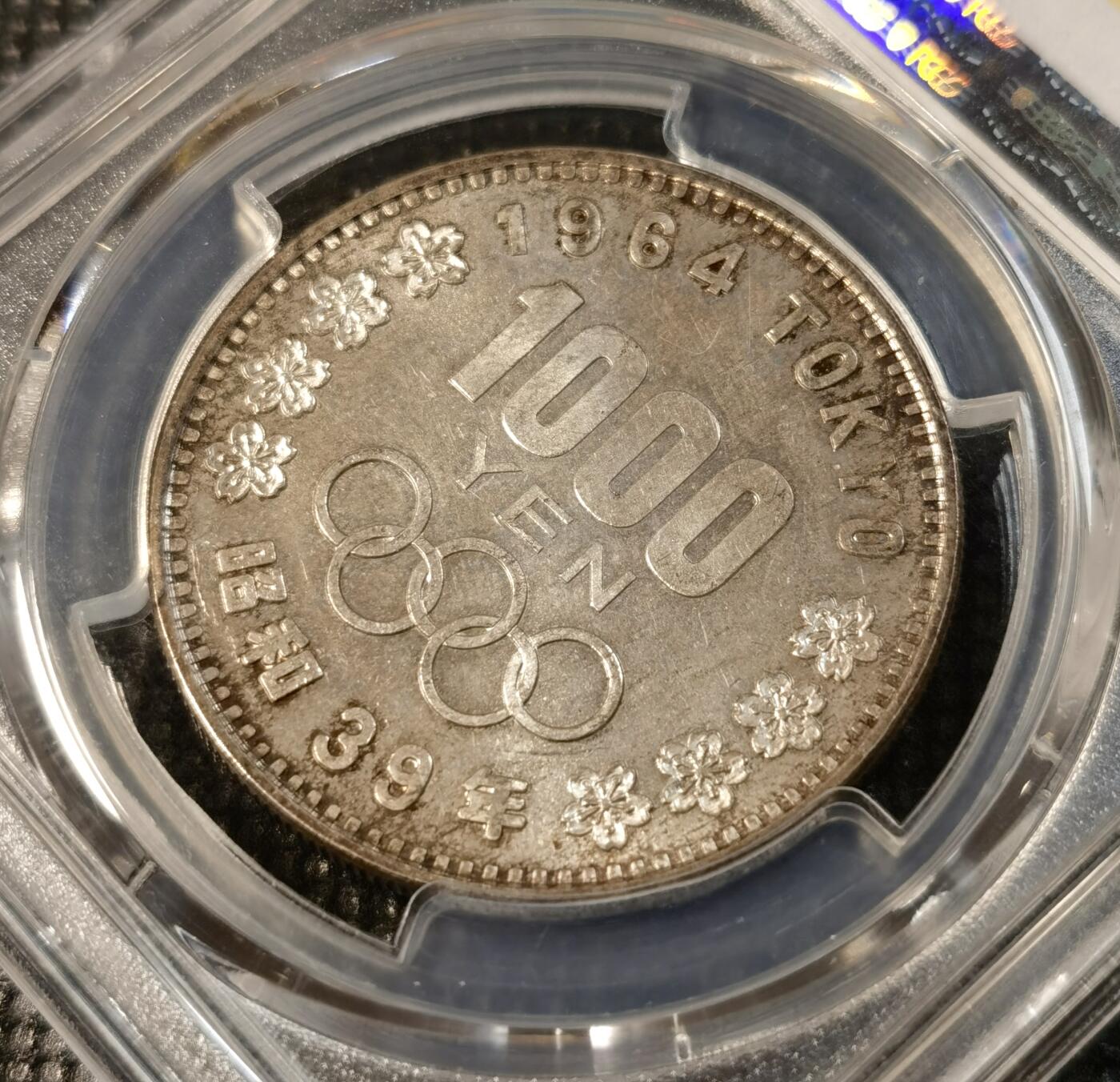 甄臻铺-世界币章拍卖（第25期），送拍享返佣金等优惠多多 PCGS-MS66 日本1964大奥1000日元，黑彩包浆