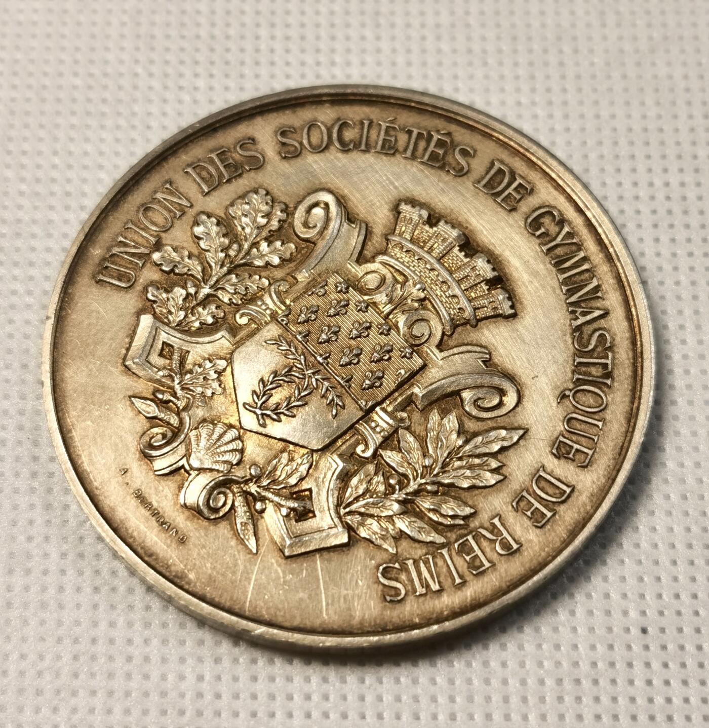  甄臻铺-世界币章拍卖（第25期），送拍享返佣金等优惠多多 1887年法国里尔体操协会颁发的镀金银章，正面刻有皇冠和盾形纹章，周围环绕橄榄枝装饰。背面刻有