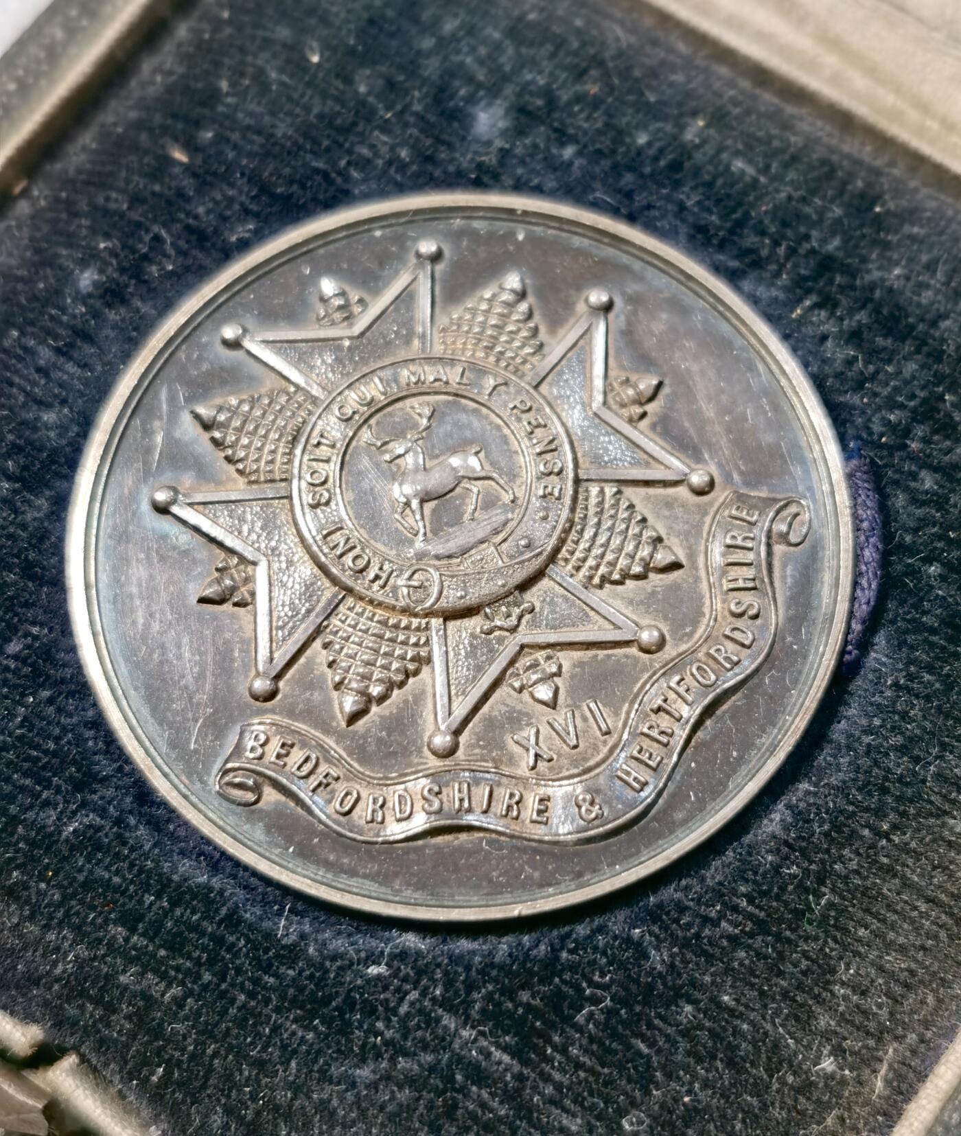  甄臻铺-世界币章拍卖（第25期），送拍享返佣金等优惠多多 英国贝特福德郡和赫特福德郡步兵团颁发的获奖者银，无获奖者刻铭，直径38毫米，重27.9克，带原盒，无银标但实测925银以上。正面是六芒星和梅花鹿图案，周围环绕着英文字母和纹章装饰。背面刻有