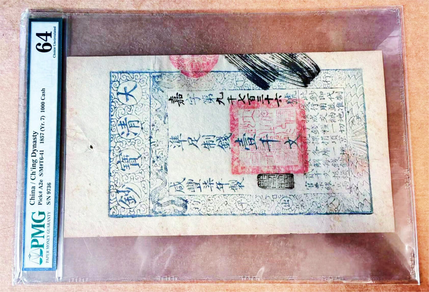 【Blue Auction】✨世界纸币精拍700期盛典——白金之夜🔥🔥🔥 C中国 大清宝钞 咸丰七年 1857年1000文 超大票幅 大红印章醒目 四周饰以龙纹、云纹和波浪纹 PMG64 老壳 历史的印记 （大清宝钞于咸丰三年开始发行，主要用于弥补清政府镇压太平天国运动的军费开支）