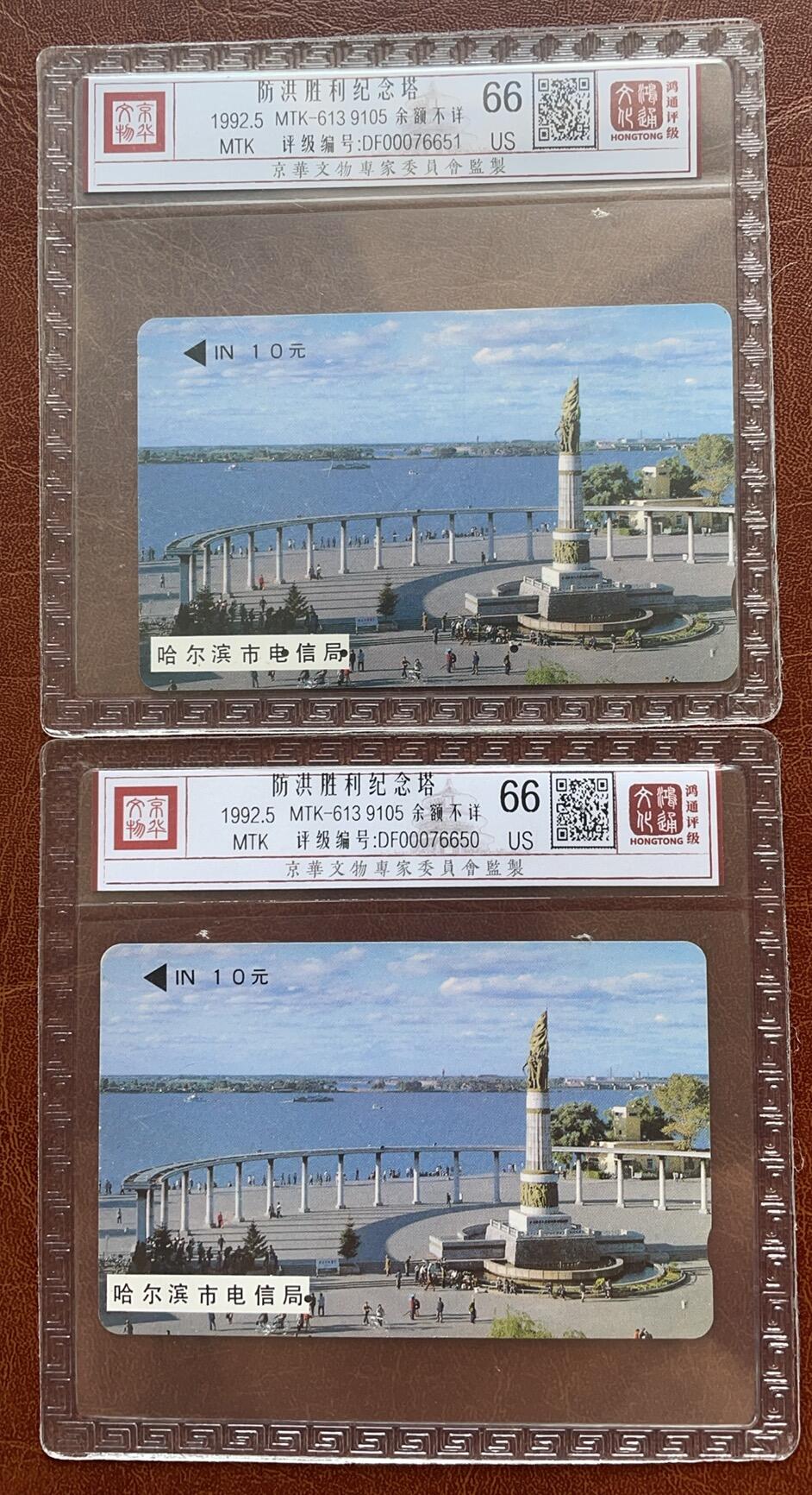 《卡拍》第335期拍卖7月26日晚22：10时延时截拍 哈尔滨韩国制式磁卡《防洪纪念塔10元面值9105》两枚旧卡，其中一枚一孔不到零，鸿通精装评级US66分。