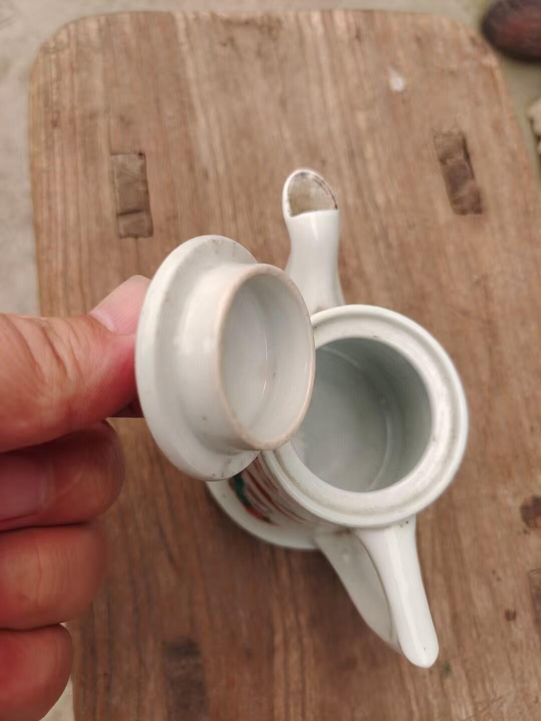 六七十年代革命红都瑞金手绘小茶壶，白色瓷胎，壶身绘制山水亭台图案，画工精美。尺寸如图，壶身完整，有轻微使用痕迹。适合收藏或日常使用。