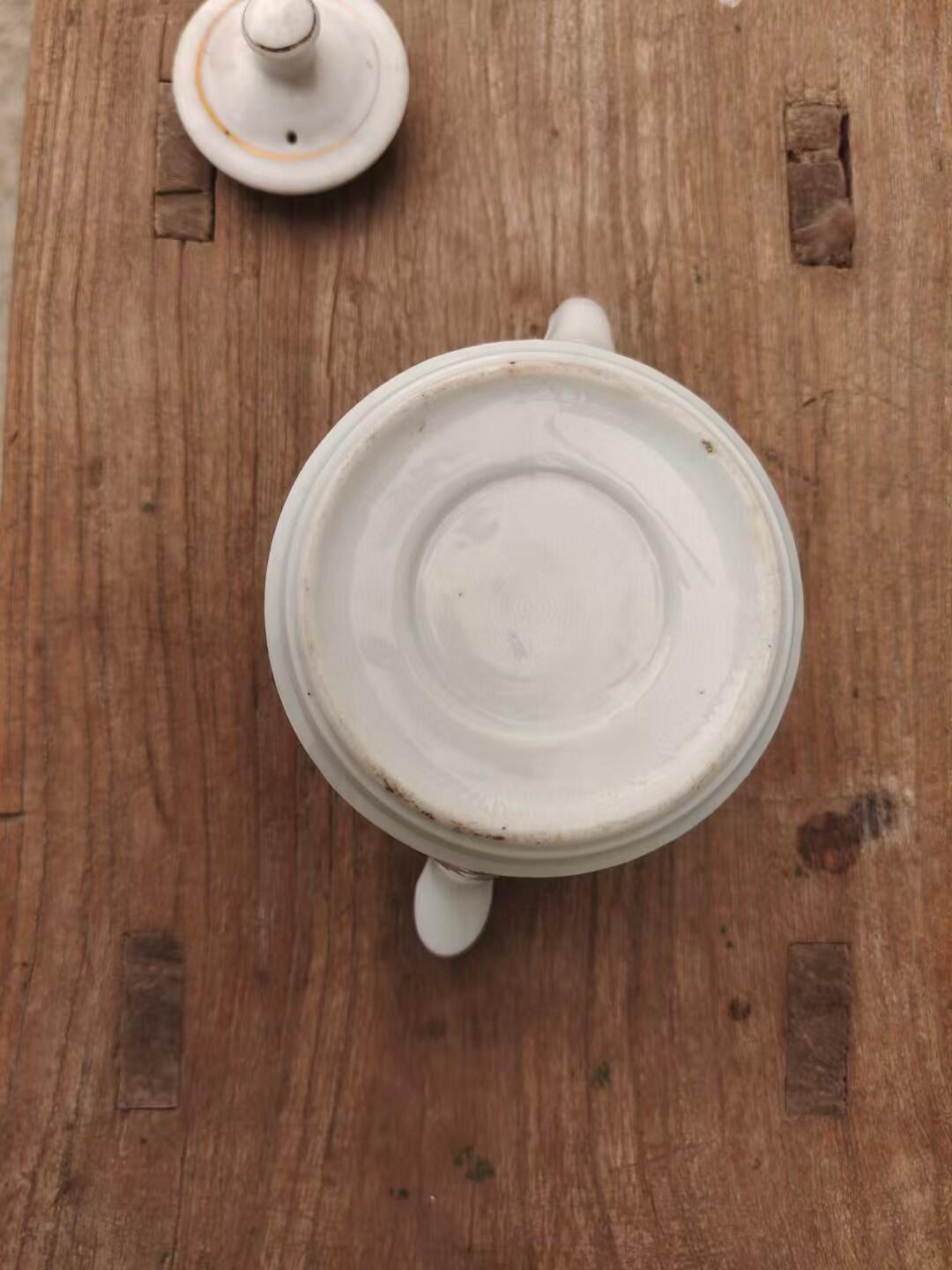 六七十年代革命红都瑞金手绘小茶壶，白色瓷胎，壶身绘制山水亭台图案，画工精美。尺寸如图，壶身完整，有轻微使用痕迹。适合收藏或日常使用。