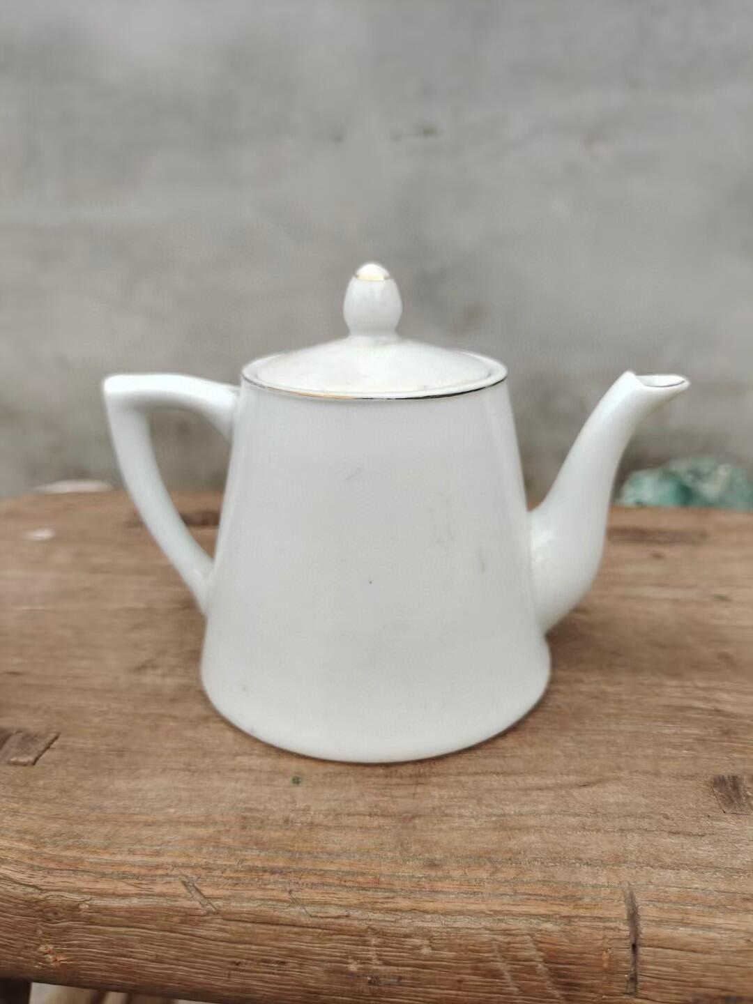 六七十年代手绘茶水壶一把 画工精美，瓷质细腻，壶身绘制山水风景图案，上有"团结 紧张 严肃 活泼"字样，口沿描金，尺寸约10厘米高，完整漂亮适合收藏或日常使用。