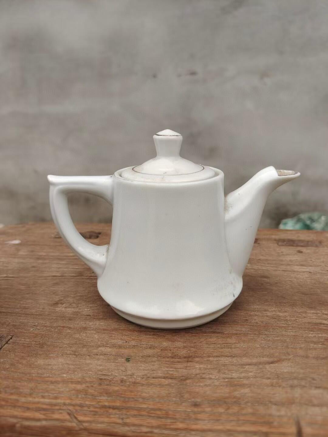 六七十年代革命红都瑞金手绘小茶壶，白色瓷胎，壶身绘制山水亭台图案，画工精美。尺寸如图，壶身完整，有轻微使用痕迹。适合收藏或日常使用。