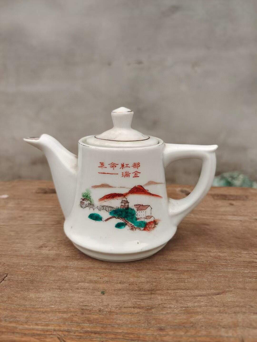 六七十年代革命红都瑞金手绘小茶壶，白色瓷胎，壶身绘制山水亭台图案，画工精美。尺寸如图，壶身完整，有轻微使用痕迹。适合收藏或日常使用。