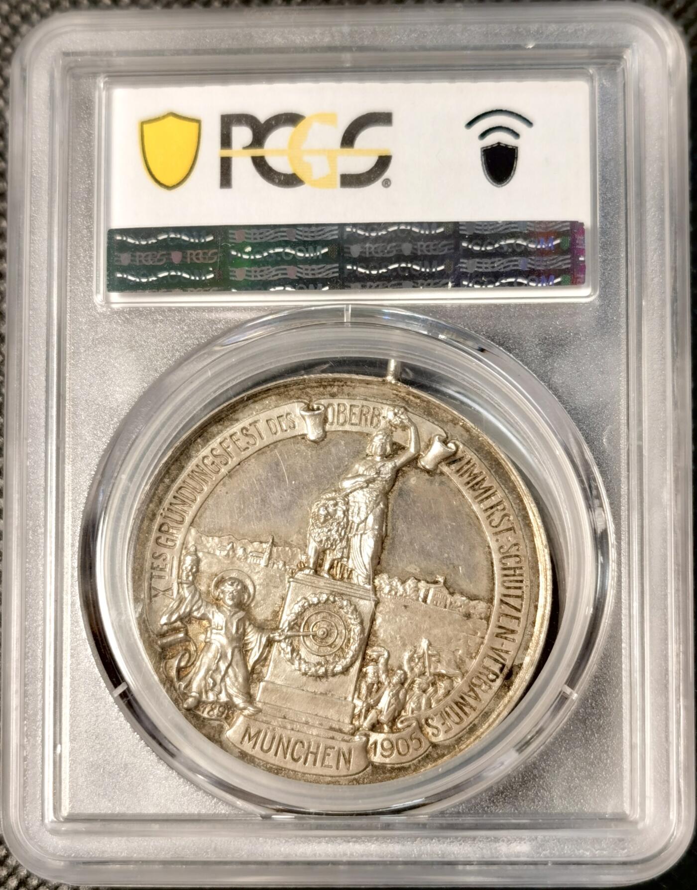  甄臻铺-世界币章拍卖（第26期），送拍享返佣金等优惠多多 PCGS-SP62 德国巴伐利亚帝国1905年颁发的纪念银章，正面刻有阿尔方斯王子头像，背面是1905年慕尼黑建立射击总会10周年庆典场景，环绕德文铭文，PCGS加厚盒。此枚纪念章由Peltzer公司制作，正面浮雕工艺精美，背面雕刻生动。正面是阿尔方斯王子戎装形象，背面是庆祝活动场景和城市风光