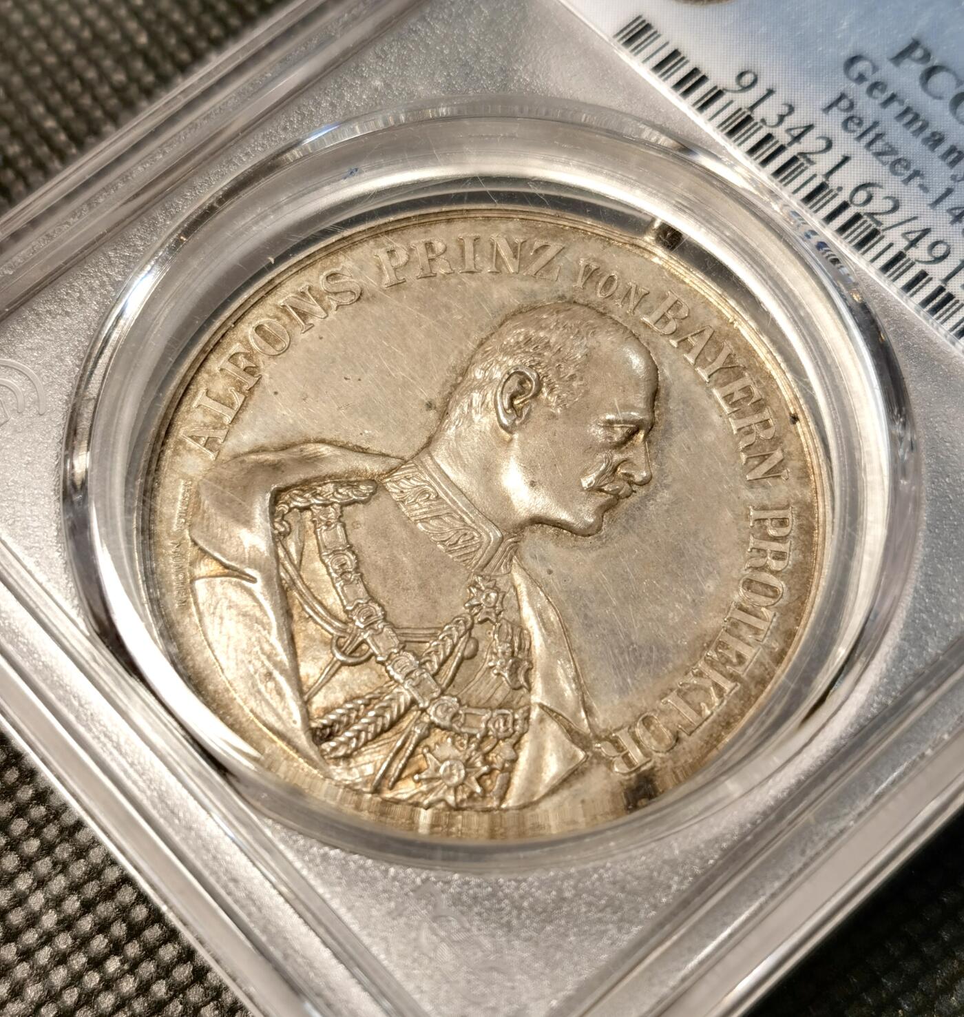  甄臻铺-世界币章拍卖（第26期），送拍享返佣金等优惠多多 PCGS-SP62 德国巴伐利亚帝国1905年颁发的纪念银章，正面刻有阿尔方斯王子头像，背面是1905年慕尼黑建立射击总会10周年庆典场景，环绕德文铭文，PCGS加厚盒。此枚纪念章由Peltzer公司制作，正面浮雕工艺精美，背面雕刻生动。正面是阿尔方斯王子戎装形象，背面是庆祝活动场景和城市风光
