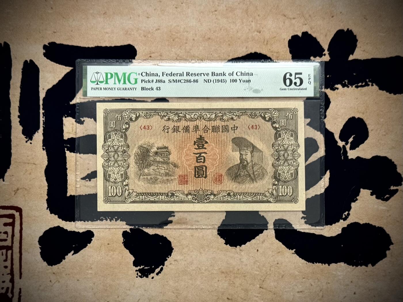  【乾奕收藏】出民国34年1945年中国联合准备银行壹百圆，右皇帝像，美国PMG65E，民国纸币经过80年能保存如此品相实属难得，喜欢的老板不要错过，评级币一切以分数为准，售出非假不退
