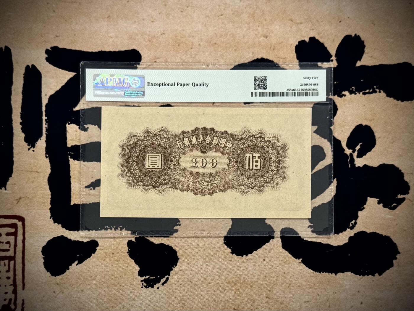  【乾奕收藏】出民国34年1945年中国联合准备银行壹百圆，右皇帝像，美国PMG65E，民国纸币经过80年能保存如此品相实属难得，喜欢的老板不要错过，评级币一切以分数为准，售出非假不退