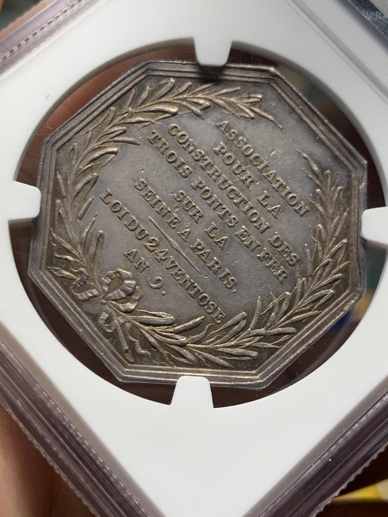 《竞宝斋》第408场 周日，周一，2场连拍 （全场包邮） NGC AU58 法国塞纳河三铁桥建设协会银章 油灯边铭（1832-1841），欧洲五彩老包浆状态，塞纳河畔的早晨，金色的阳光洒在波光粼粼的河面上，沿岸的建筑都沐浴在晨光下，一片宁静的景象