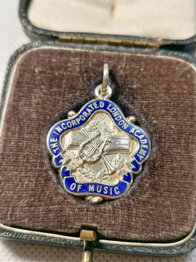 甄臻铺-世界币章拍卖（第28期），送拍享返佣金等优惠多多 The Incorporated London Academy of Music 1938年圣诞节演讲银奖章，正面是学院徽章图案，背面刻有CHRISTMAS 1938 ELOCUTION GLADYS I. ROBSON字样，品相如图，珐琅彩边缘完整，背面刻字清晰重13.6g，长27mm。带原盒