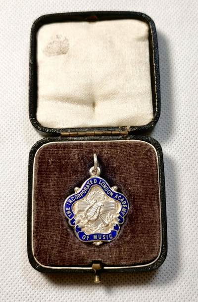 甄臻铺-世界币章拍卖（第28期），送拍享返佣金等优惠多多 The Incorporated London Academy of Music 1938年圣诞节演讲银奖章，正面是学院徽章图案，背面刻有CHRISTMAS 1938 ELOCUTION GLADYS I. ROBSON字样，品相如图，珐琅彩边缘完整，背面刻字清晰重13.6g，长27mm。带原盒