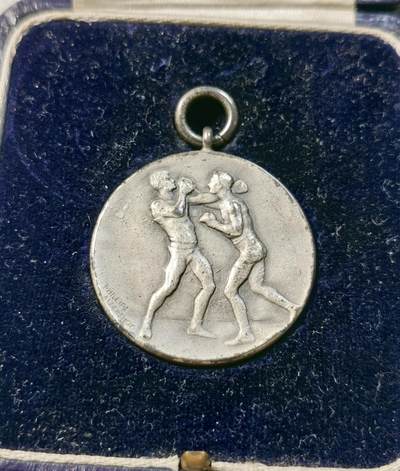 甄臻铺-世界币章拍卖（第28期），送拍享返佣金等优惠多多 1928年英国拳击比赛奖牌，正面是两个拳击手对战图案，背面是百合花图案和LXIII罗马数字。重20.4g，直径32mm。带原盒