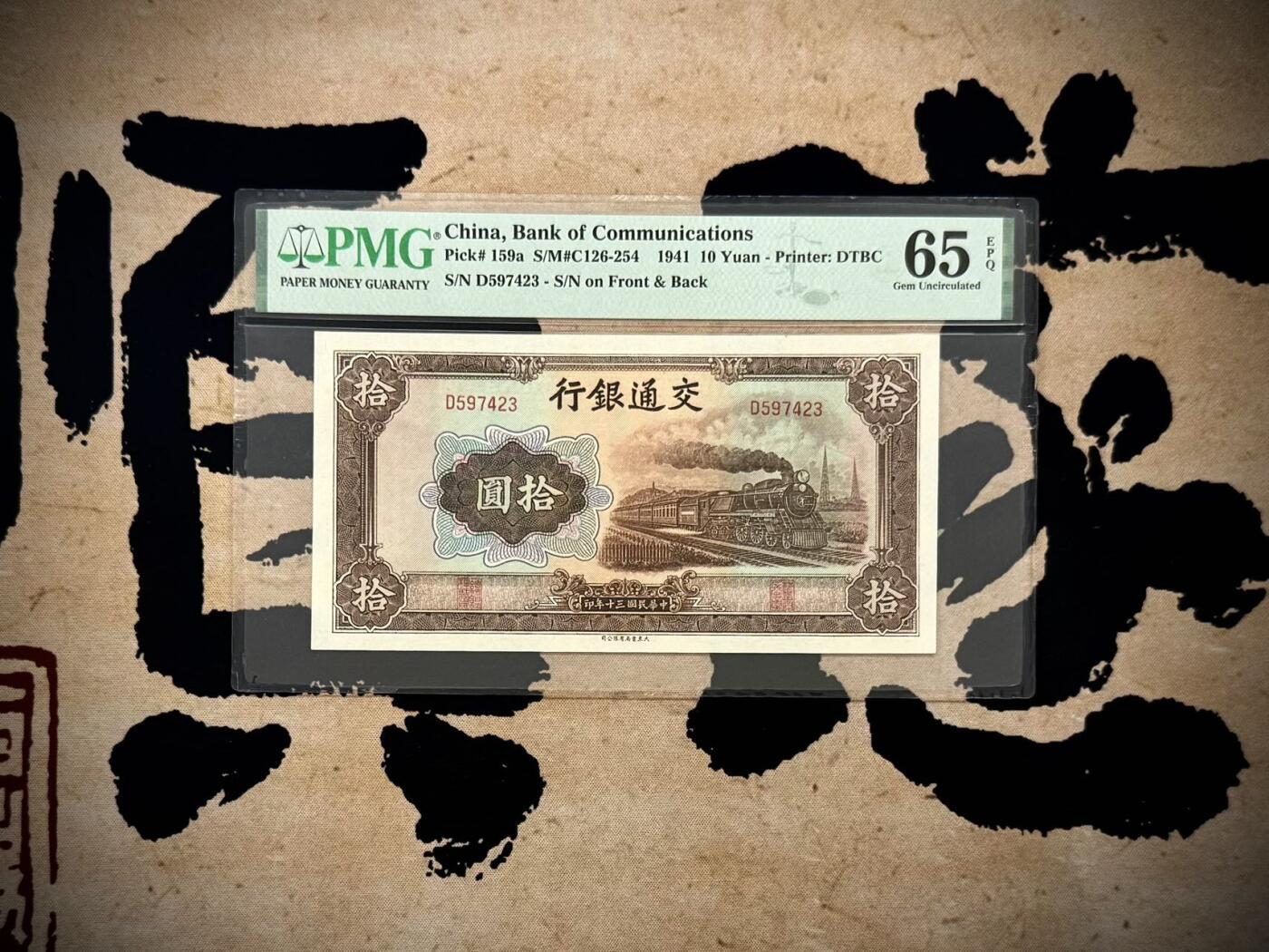 【乾奕收藏】出1941年民国30年交通银行大东版拾圆，乱蛇号，美国PMG65E，民国纸币经过80年能保存如此品相实属难得，喜欢的老板不要错过，评级币一切以分数为准，售出非假不退