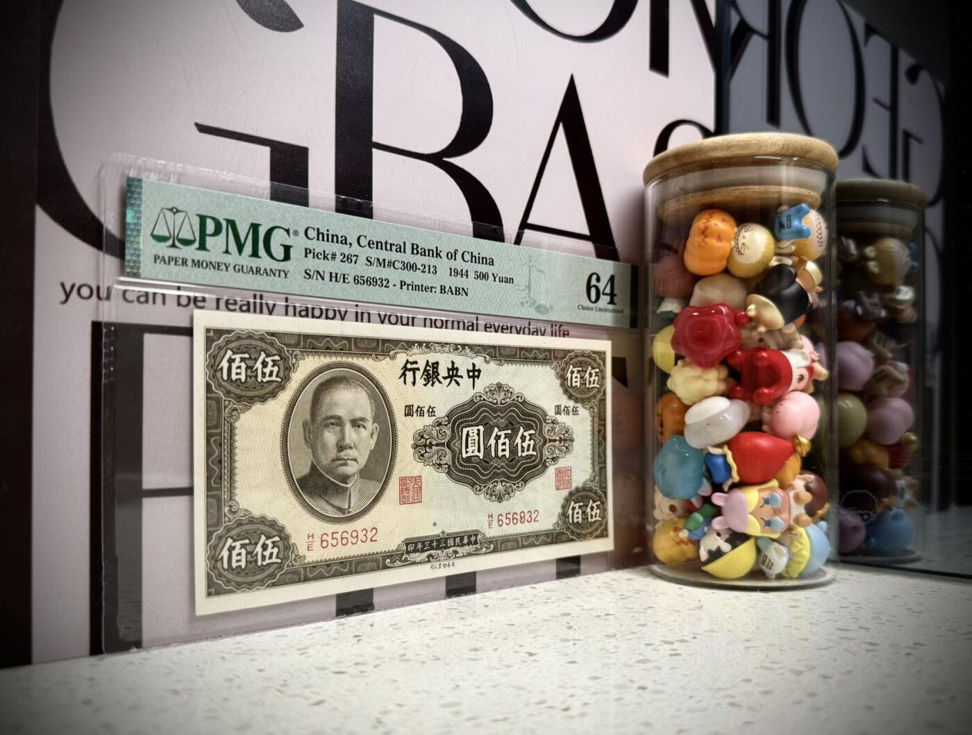（自动截拍）PMG评级民国纸币专拍第202508018期，全场包邮 【乾奕收藏】出民国33年1944年中央银行英美版伍佰圆，号码全程无47，热门品种，美国PMG64分