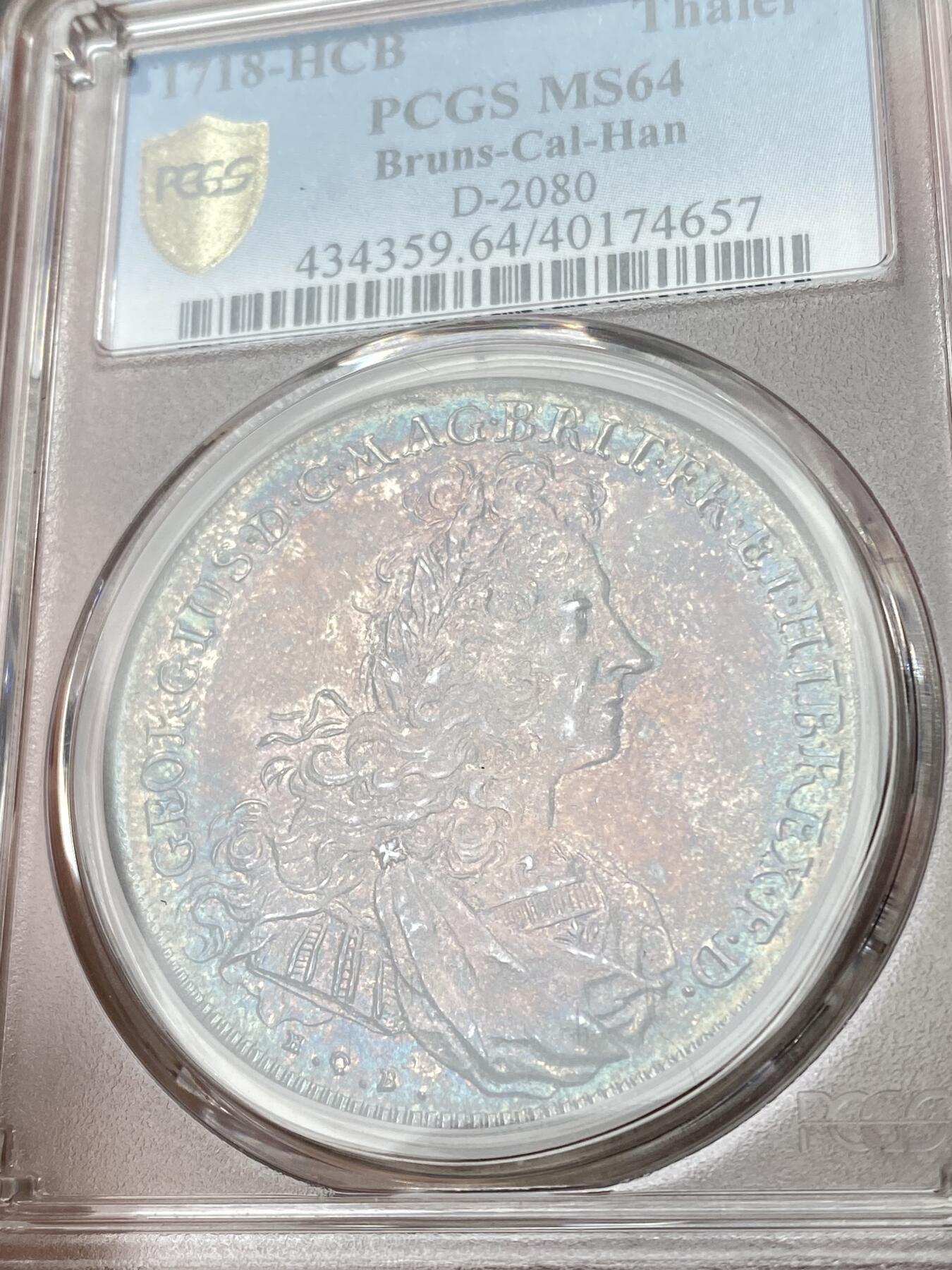 万国钱币拍卖第051期 NGC MS64 1718布伦瑞克-吕纳堡-汉诺威狮马盾徽大泰勒 极其罕见的一枚英系泰勒 正面君主为汉诺威选帝侯同时也是英国汉诺威王朝的第一位国王乔治一世 而这位英语不太流利的国王只能任命大臣替他处理政务 由此也成为了英国首相一职的开端 经典汉诺威狮马纹章 极其绚丽的欧陆五彩 一枚英德双修的顶级藏品 PC唯一冠军分