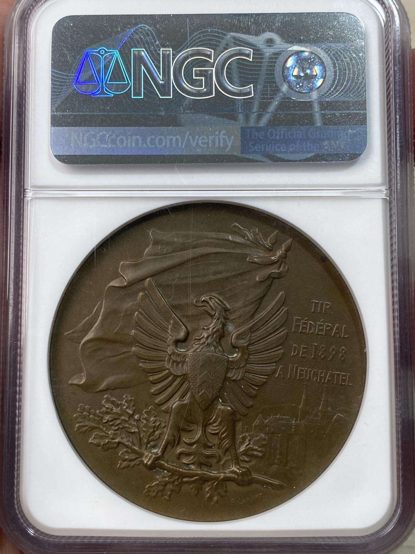 万国钱币拍卖第051期 NGC MS65 1898年瑞士纳沙泰尔射击节大铜章 直径45毫米，正面是射击场景浮雕，背面是雄鹰和盾牌图案，刻有