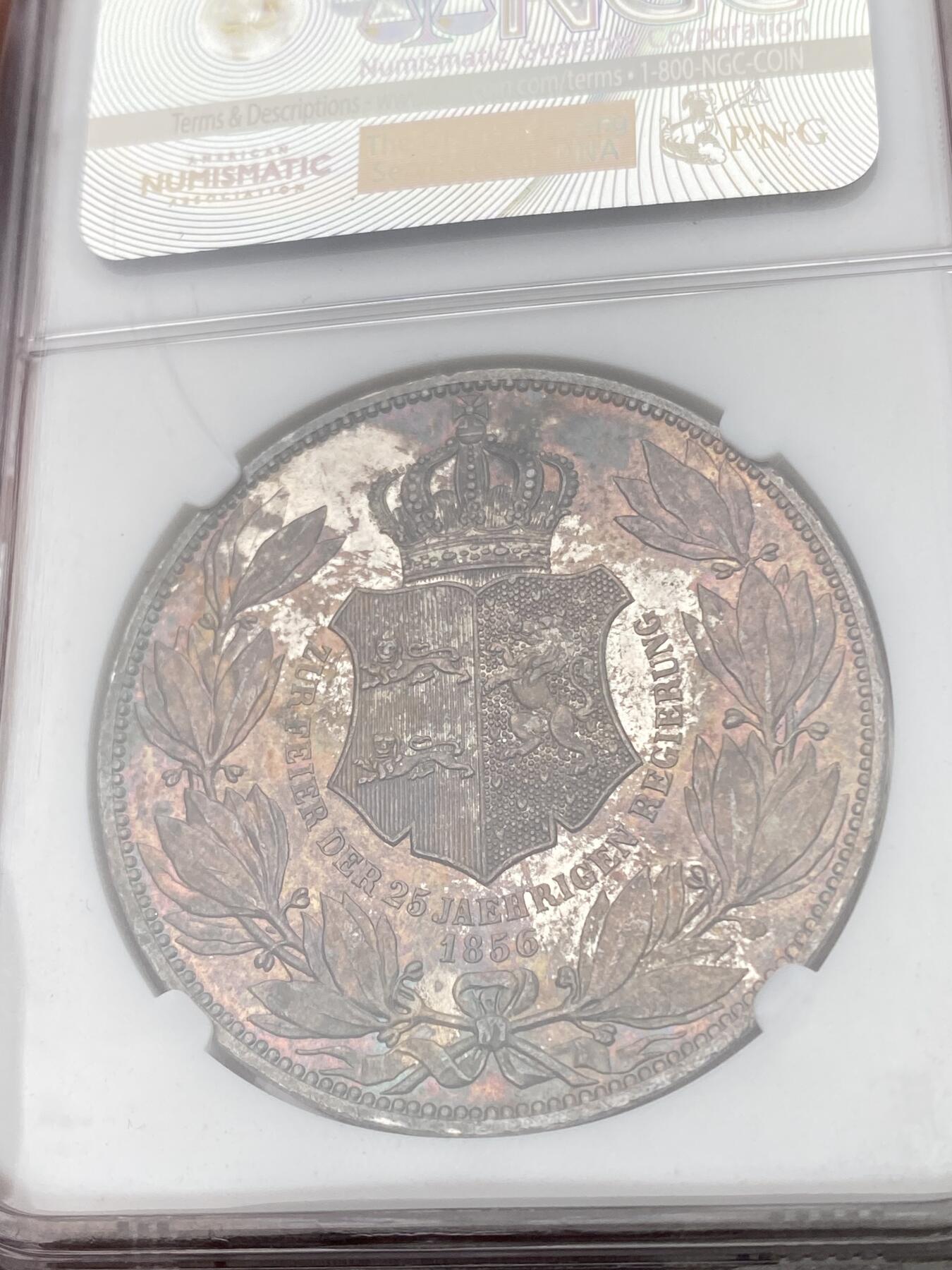 万国钱币拍卖第051期 NGC MS63 1856年德国不伦瑞克-吕纳堡威廉国王加冕25周年盾徽2泰勒 整体孔雀绿红酒色彩环绕 类镜面质感 NGC老盒