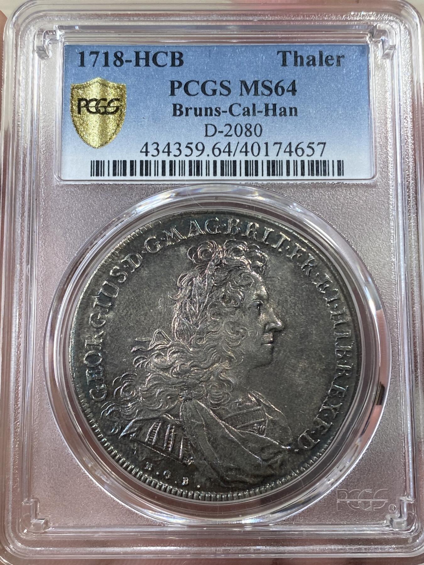 万国钱币拍卖第051期 NGC MS64 1718布伦瑞克-吕纳堡-汉诺威狮马盾徽大泰勒 极其罕见的一枚英系泰勒 正面君主为汉诺威选帝侯同时也是英国汉诺威王朝的第一位国王乔治一世 而这位英语不太流利的国王只能任命大臣替他处理政务 由此也成为了英国首相一职的开端 经典汉诺威狮马纹章 极其绚丽的欧陆五彩 一枚英德双修的顶级藏品 PC唯一冠军分