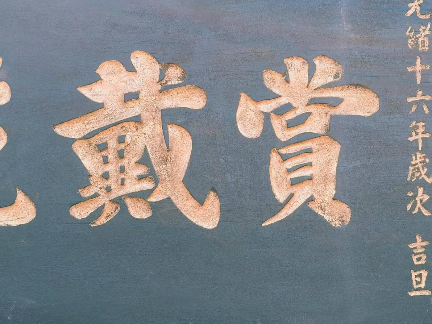 赏戴花翎是清代皇帝授予有功之臣或特殊贡献者的荣誉性冠饰，以孔雀翎制成，分单眼、双眼、三眼三个等级，象征身份与功勋。 乡下拆迁淘得，大清光绪十六年，皇上钦赐给总兵，陈一铭的，大号柏木老官匾，赏戴花翎一块。阴工描金字，材质好，个头够大。品相完整牢固，值得收藏和拥有。 尺寸长宽厚214/91/5cm。