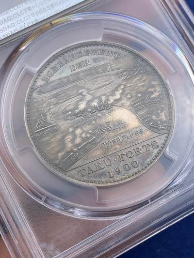 《竞宝斋》第410场 周日，周一，2场连拍 （全场包邮） PCGS SP63 德国1900年庚子八国联军侵华天津大沽口炮战银章 镜面原味深色包浆 透出蓝紫色虹彩 德式深邃 柏林造币厂 正面德舰伊尔提斯号 背面海河入海口渤海湾防御工事地图 标注了渤海湾，清军船坞，兵营，南炮台，北炮台等等以及海上中炮燃烧的舰船 呈现海战战场炮火连天 战况激烈生动场面 中国题材名誉品种
