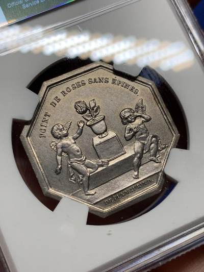 《竞宝斋》第410场 周日，周一，2场连拍 （全场包邮） NGC MS64 高分  苦与乐，婚姻系列中最精彩一枚，正面图案为苦与乐双面神，背面责任一对爱情的小天使，一个正在摘取带刺的玫瑰（玫瑰代表婚姻与爱情），一个被被玫瑰刺扎伤正在哭泣，像极了爱情的苦与乐