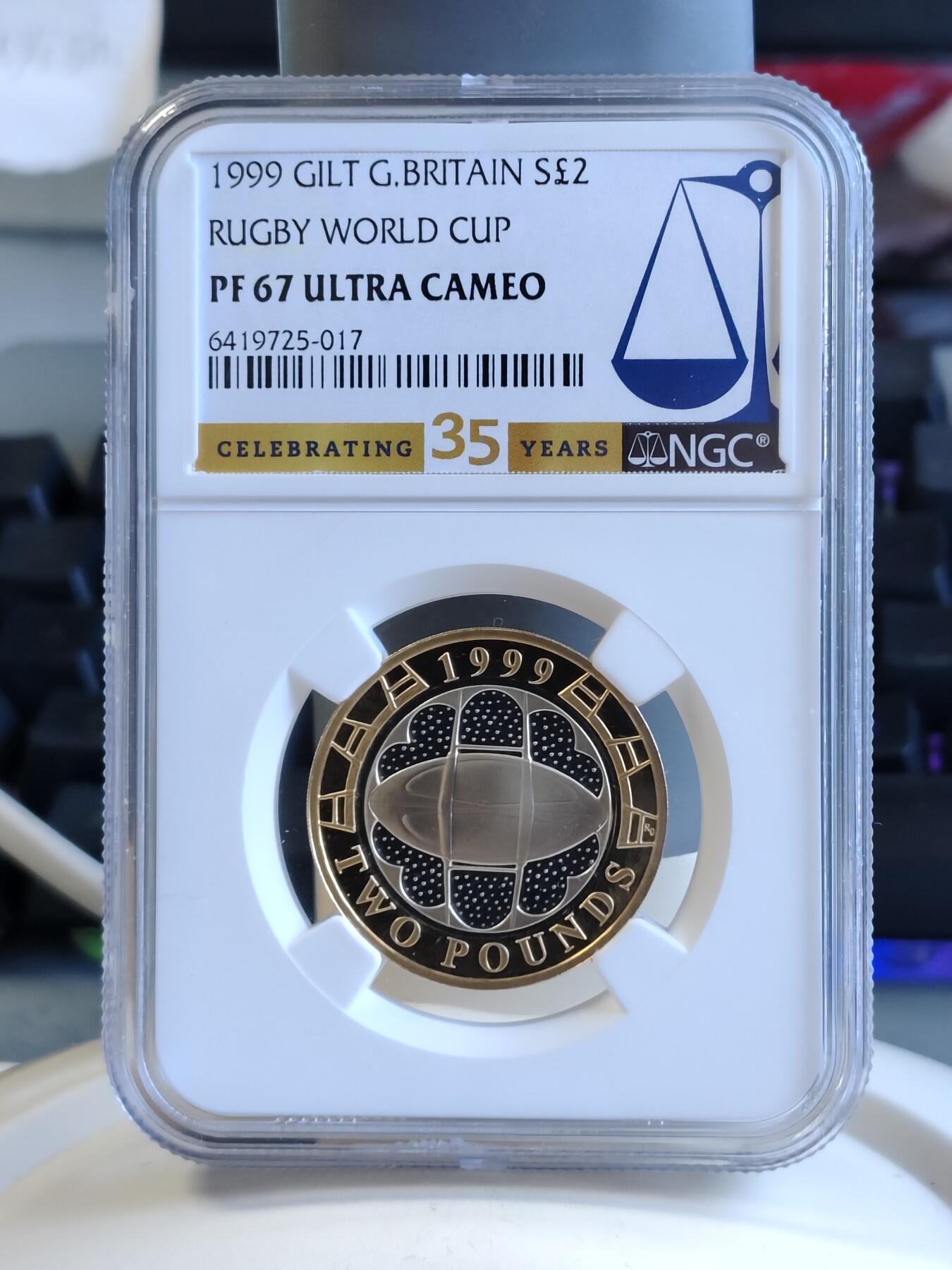 第171期拍卖【长期征集拍品】 英国1999年2镑精制双色银币 橄榄球世界杯 12克925银 外圈镀金 发行量：约1万枚 NGC PF67 UC