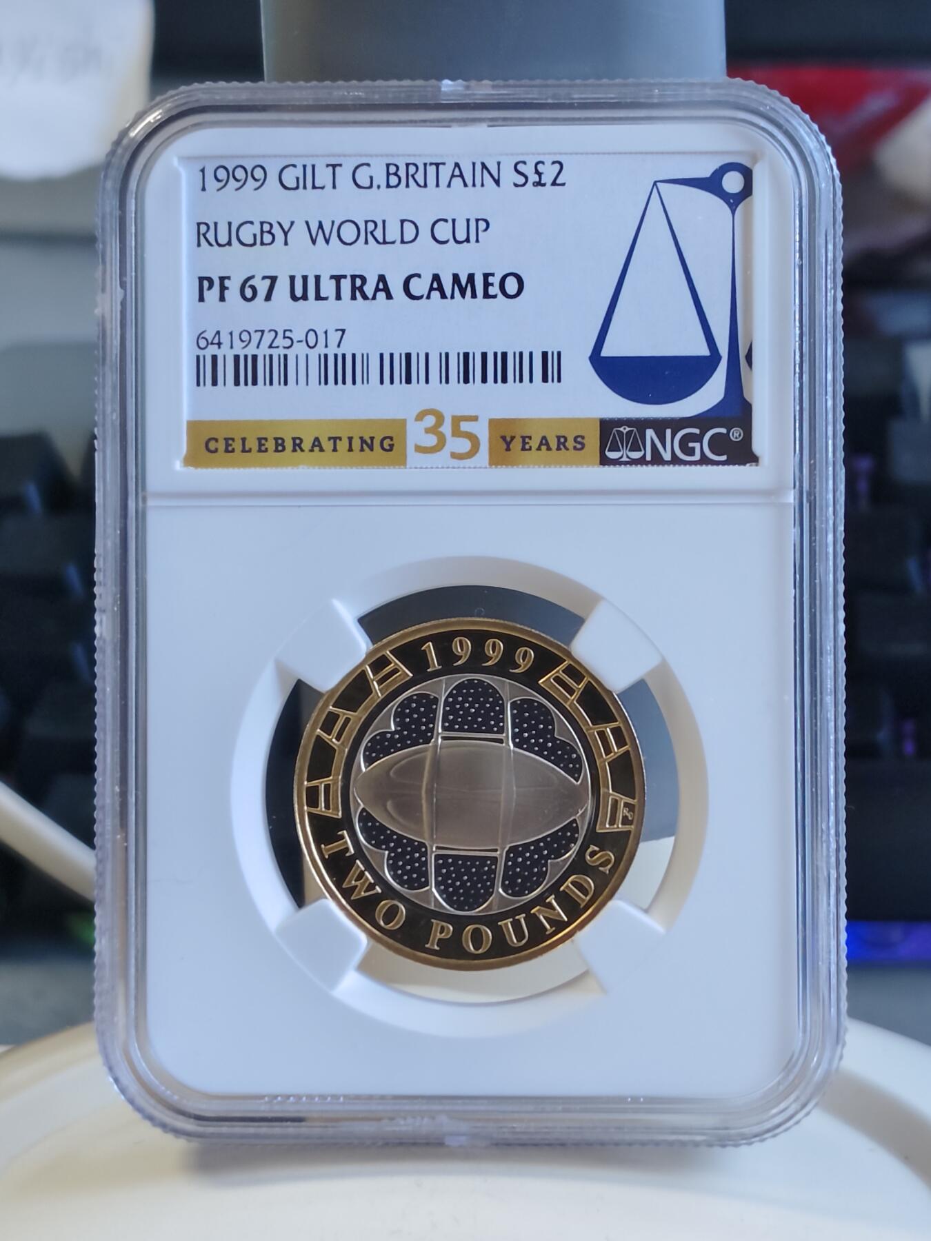 第171期拍卖【长期征集拍品】 英国1999年2镑精制双色银币 橄榄球世界杯 12克925银 外圈镀金 发行量：约1万枚 NGC PF67 UC