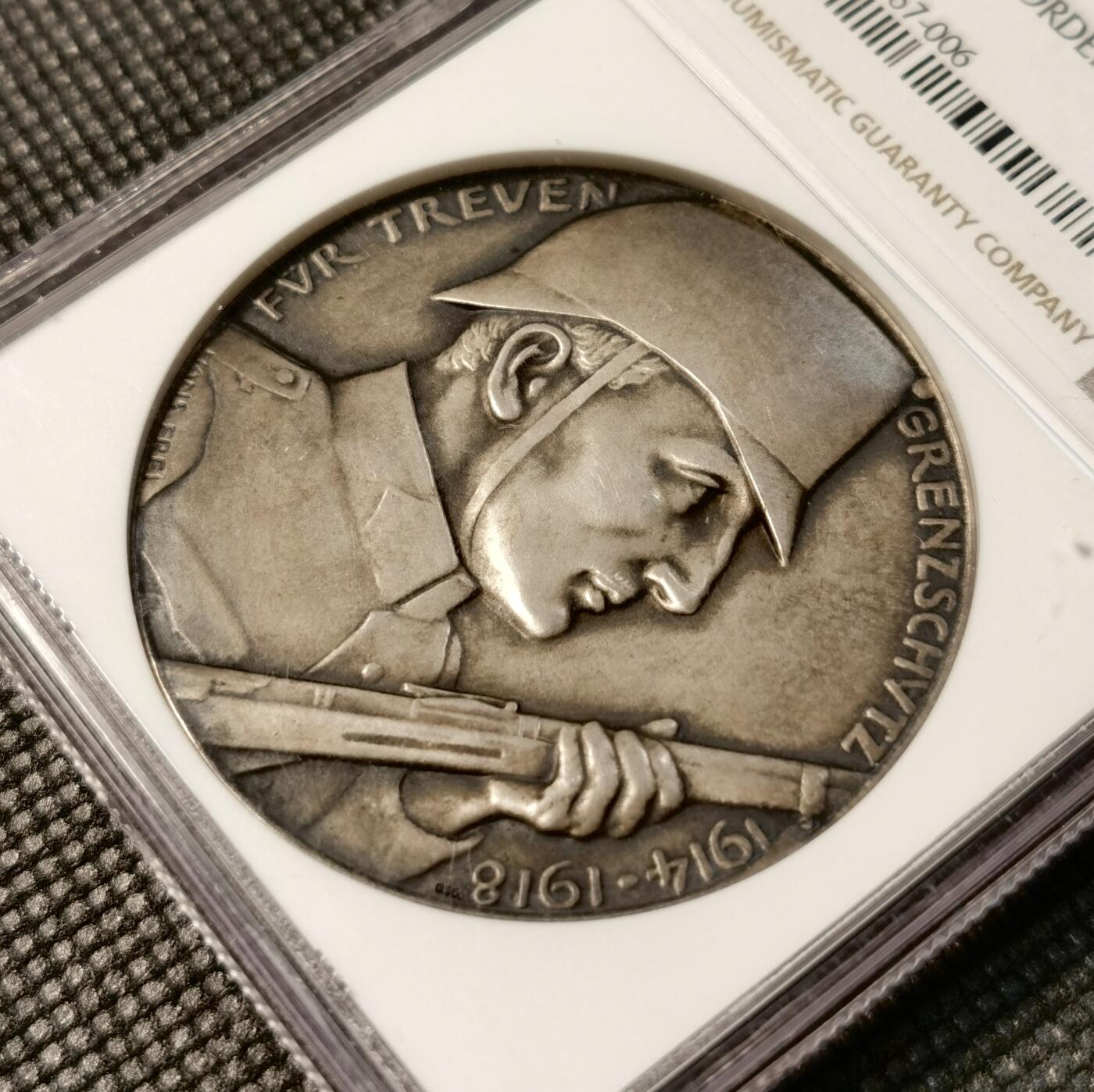 甄臻铺-世界币章拍卖（第30期），送拍享返佣金等优惠多多 NGC-MS64 瑞士1918年忠诚边防军颁发的纪念银章，直径45毫米，参考手册编号AEPPLI-279。正面是士兵持枪侧脸像，背面是盾牌和火焰纹章图案，由当地市政厅授权发行，工艺精湛