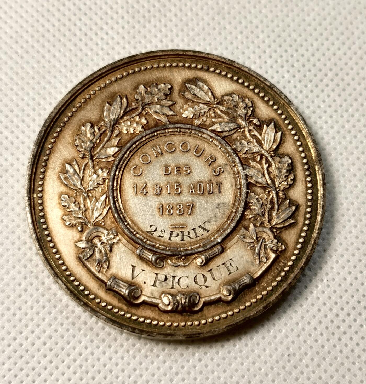 甄臻铺-世界币章拍卖（第30期），送拍享返佣金等优惠多多 1887年法国里尔体操协会颁发的鎏金银章，正面刻有皇冠和盾形纹章，周围环绕橄榄枝装饰。背面刻有