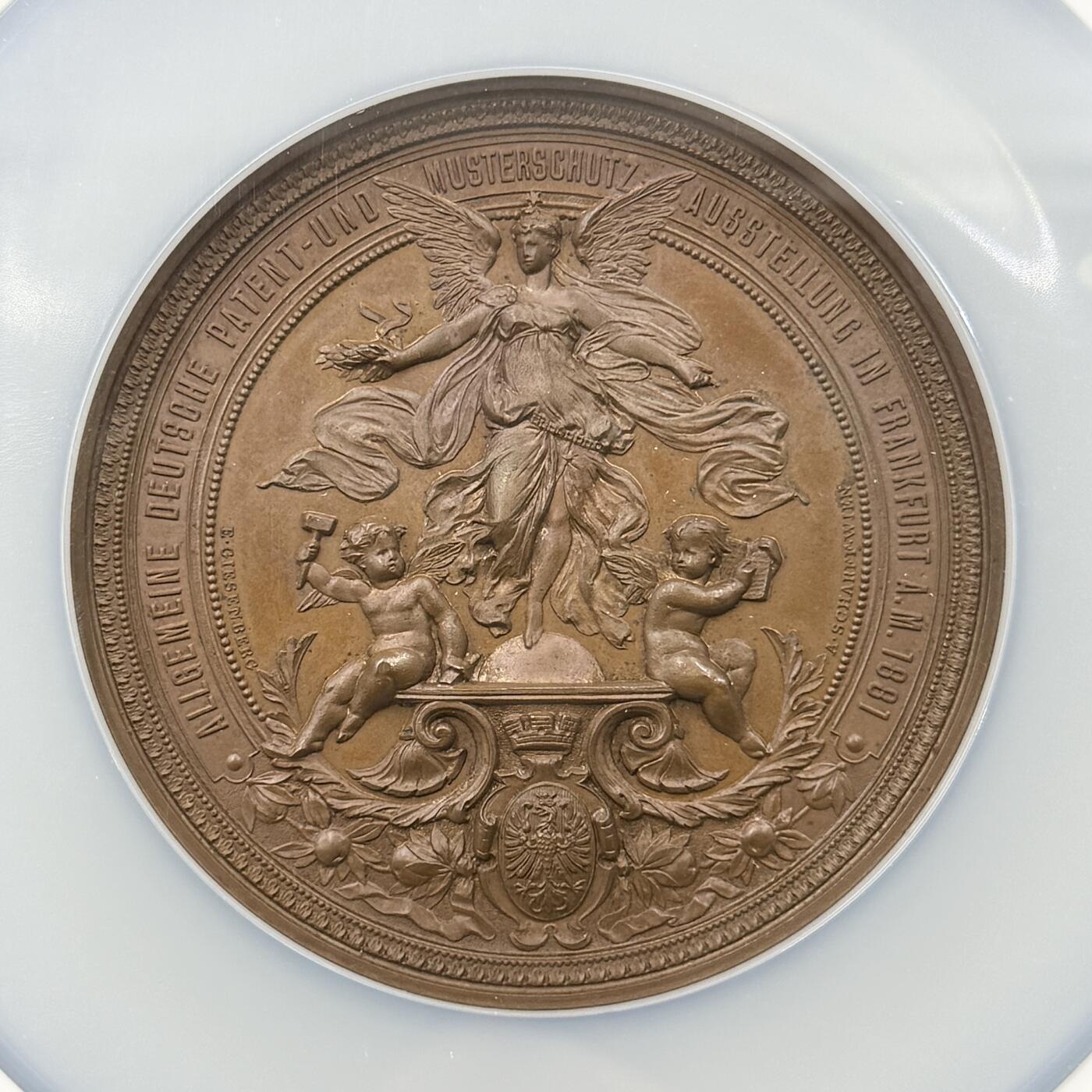 「木头集藏」章牌精品专场！ Anton Scharff ～1881年德国法兰克福专利与设计保护展览会大铜章，MS 64 ，直径：63mm，沙夫代表作品，正面中央刻画带翅膀的女性形象（象征着创意、守护或胜利），姿态舒展，周围有两个小天使形象，一个手持工具（似代表发明、创造），另一个手持书卷（似代表知识、专利文献等），整体营造出对发明创造、专利保护的歌颂与推崇氛围，品相很不错！