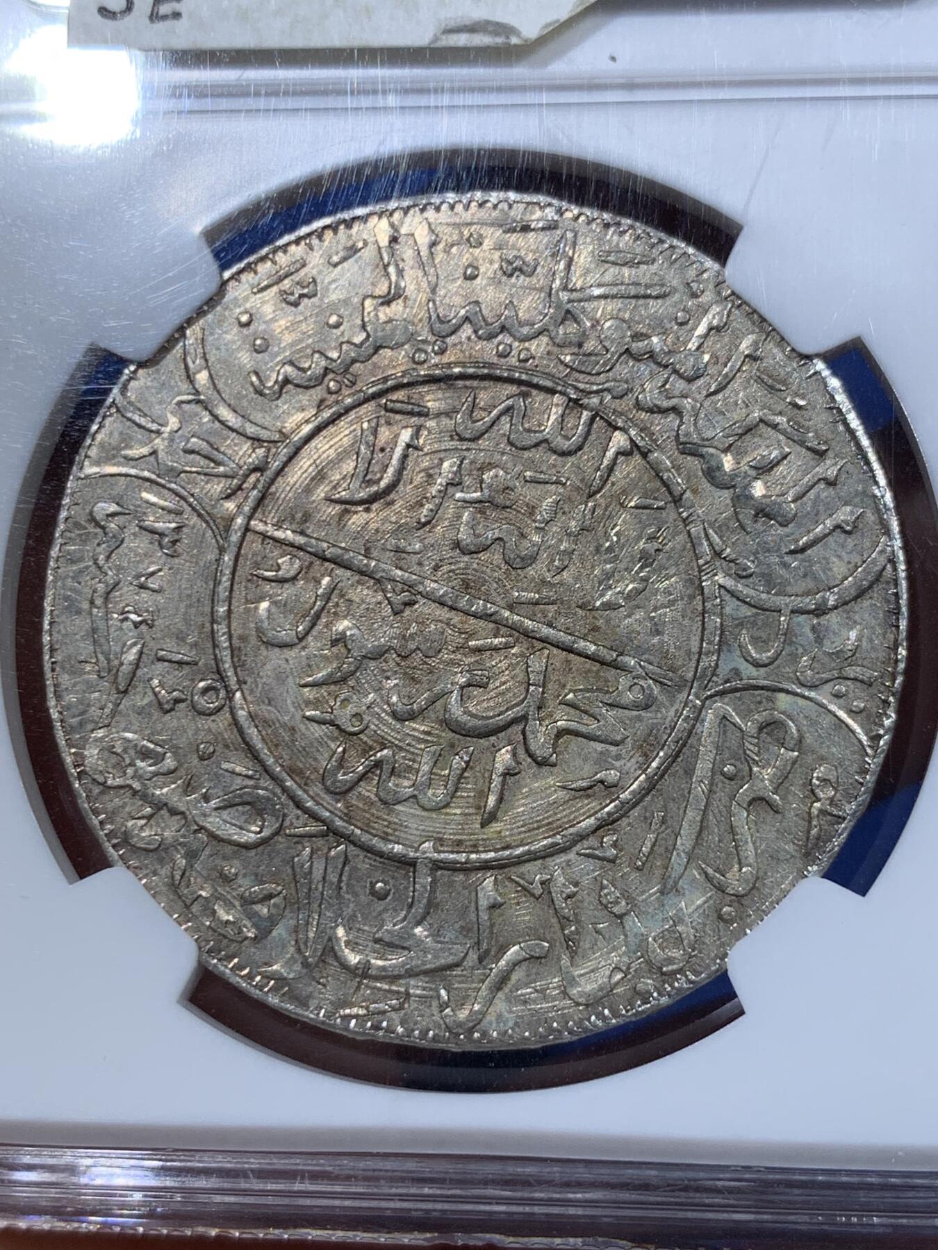 《竞宝斋》第411场 周日，周一，周二，3场连拍 （全场包邮） NGC MS62 也门AH1374(1955)弯刀克朗大银币  少见网红品种，有分难得！该系列很多都是以“大奶妈”等贸易银币为币坯，后期压制的；这枚可以清晰地看见弯刀的刀刃部分有原币坯的细节痕迹，非常值得玩味