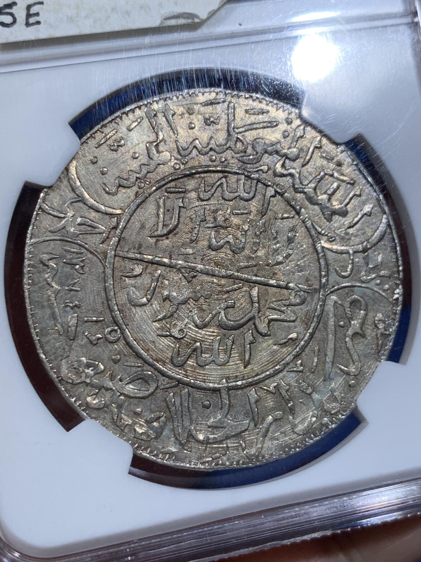 《竞宝斋》第411场 周日，周一，周二，3场连拍 （全场包邮） NGC MS62 也门AH1374(1955)弯刀克朗大银币  少见网红品种，有分难得！该系列很多都是以“大奶妈”等贸易银币为币坯，后期压制的；这枚可以清晰地看见弯刀的刀刃部分有原币坯的细节痕迹，非常值得玩味